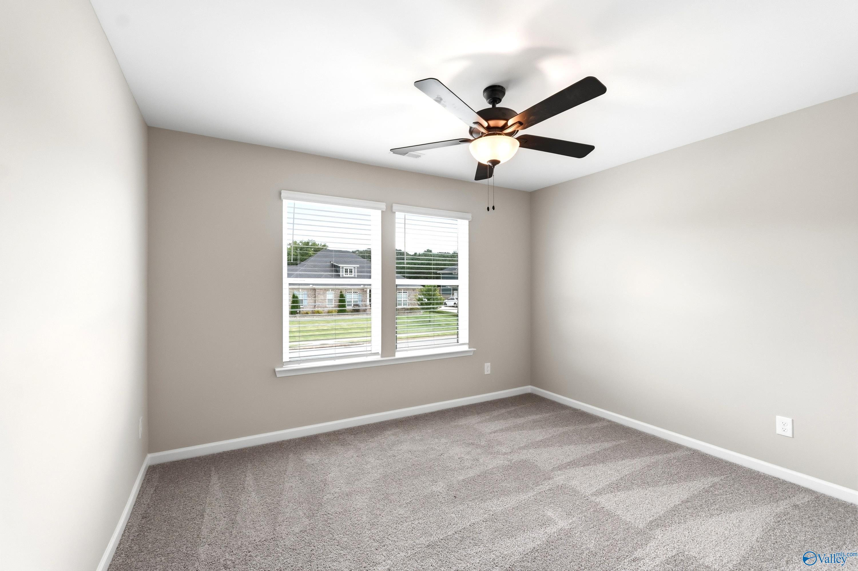 Bright secondary bedroom with plush carpeting and ceiling fan in The Dorado floor plan at Riverton Preserve, Huntsville, AL.