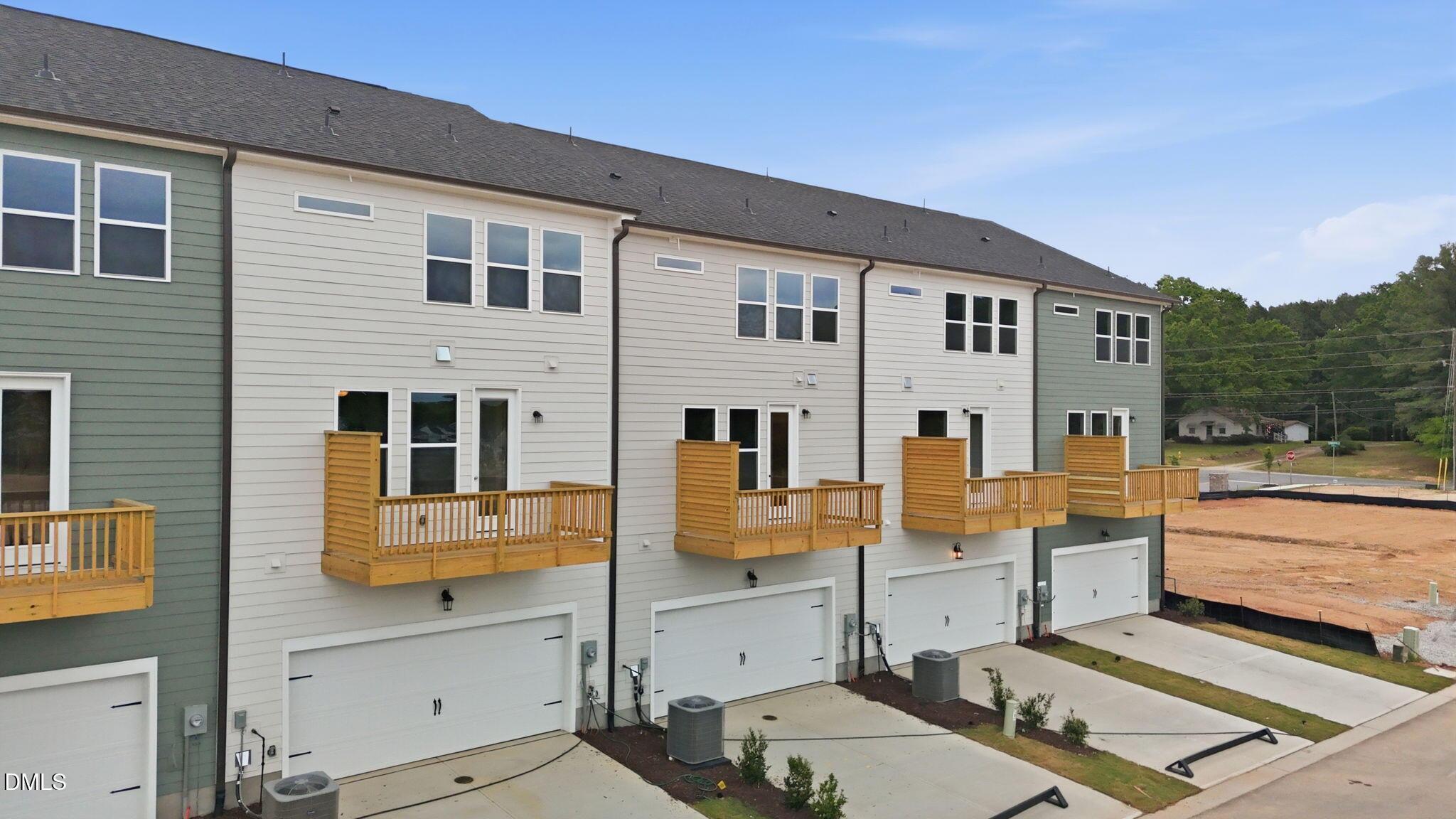 Three-story townhomes with two-car garages and private wooden balconies in Camden Park, Knightdale, North Carolina.