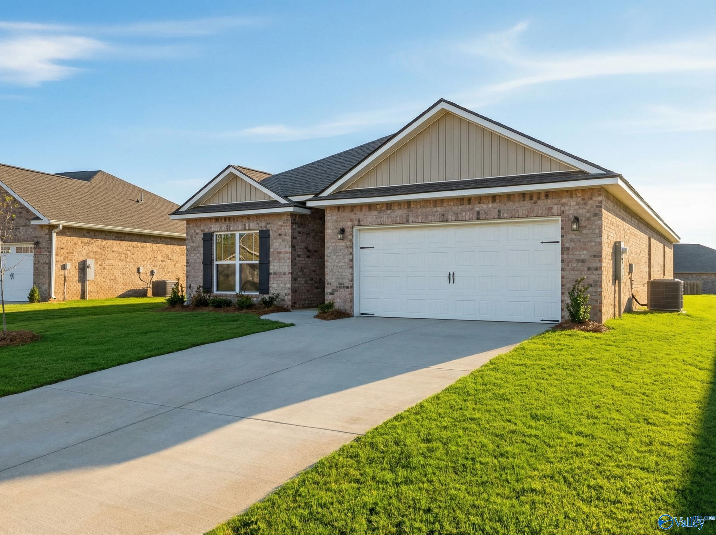 Modern 1-story brick home with 2-car garage, driveway, and lush green lawn in Creekside, Harvest, Alabama by Davidson Homes The Everett