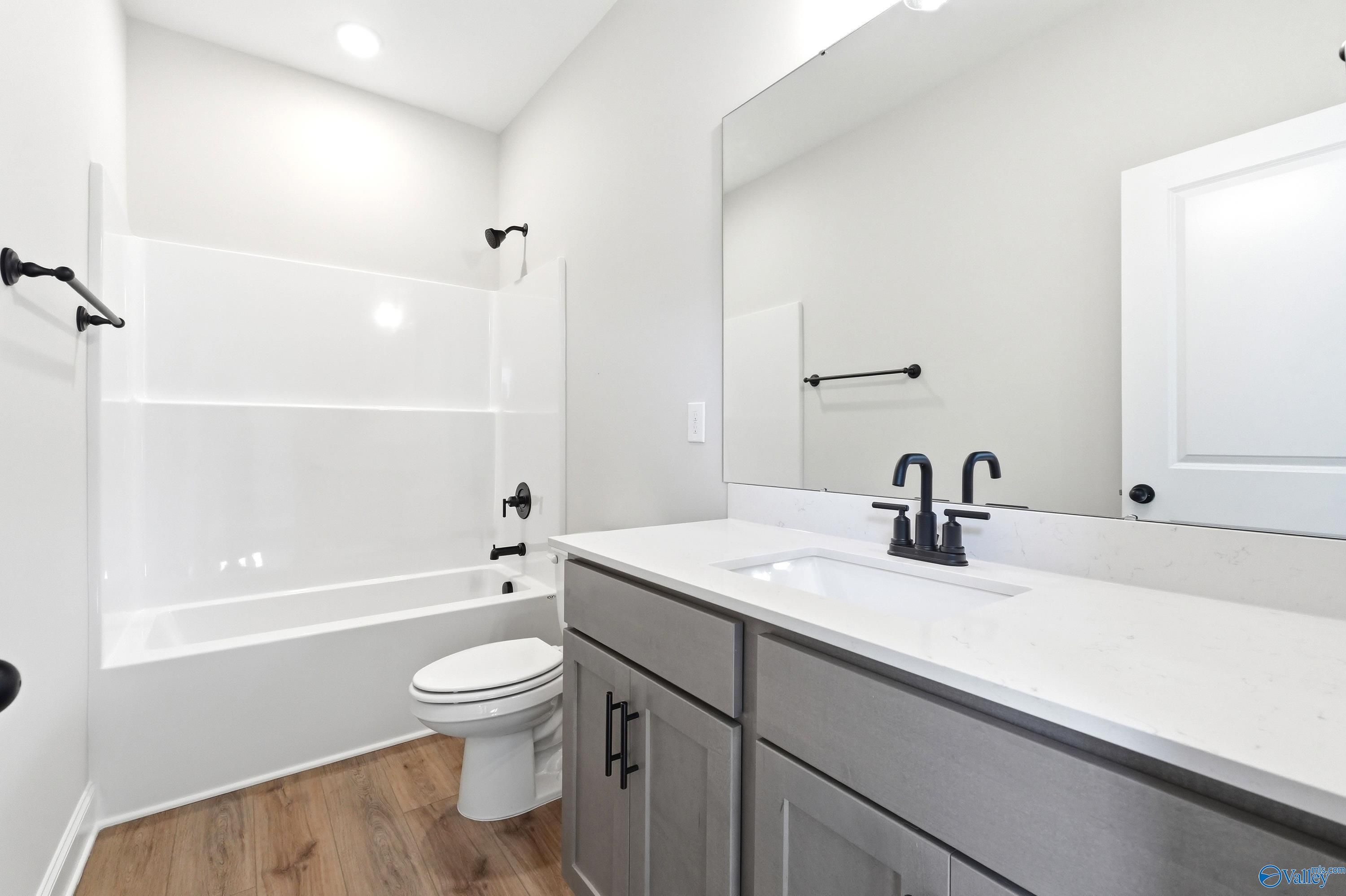 Modern bathroom with gray vanity, white quartz countertop, and tub-shower combo in The Daphne plan, Clearview, Hazel Green.
