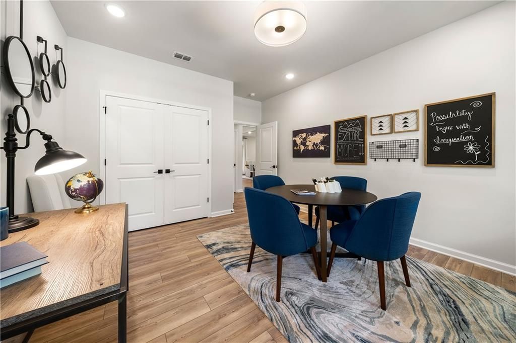Cozy home office with wooden desk, globe, round table, blue chairs, world map and blackboard in Davidson Homes The Willow B, Riverwood, Dallas, GA