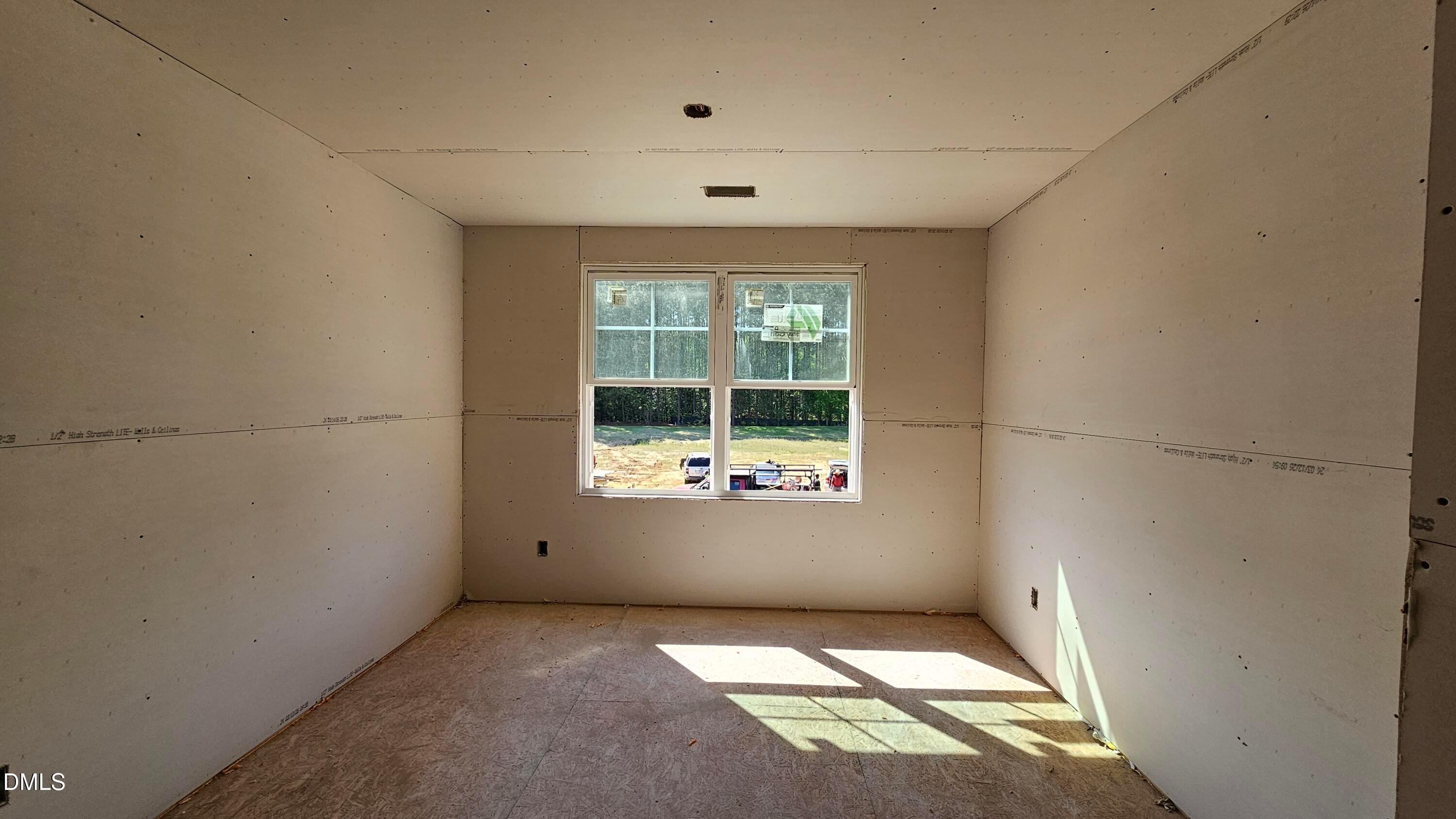 Unfinished bedroom with drywall and natural light in The Graham Interior floor plan at Springvale, Fuquay-Varina, NC.