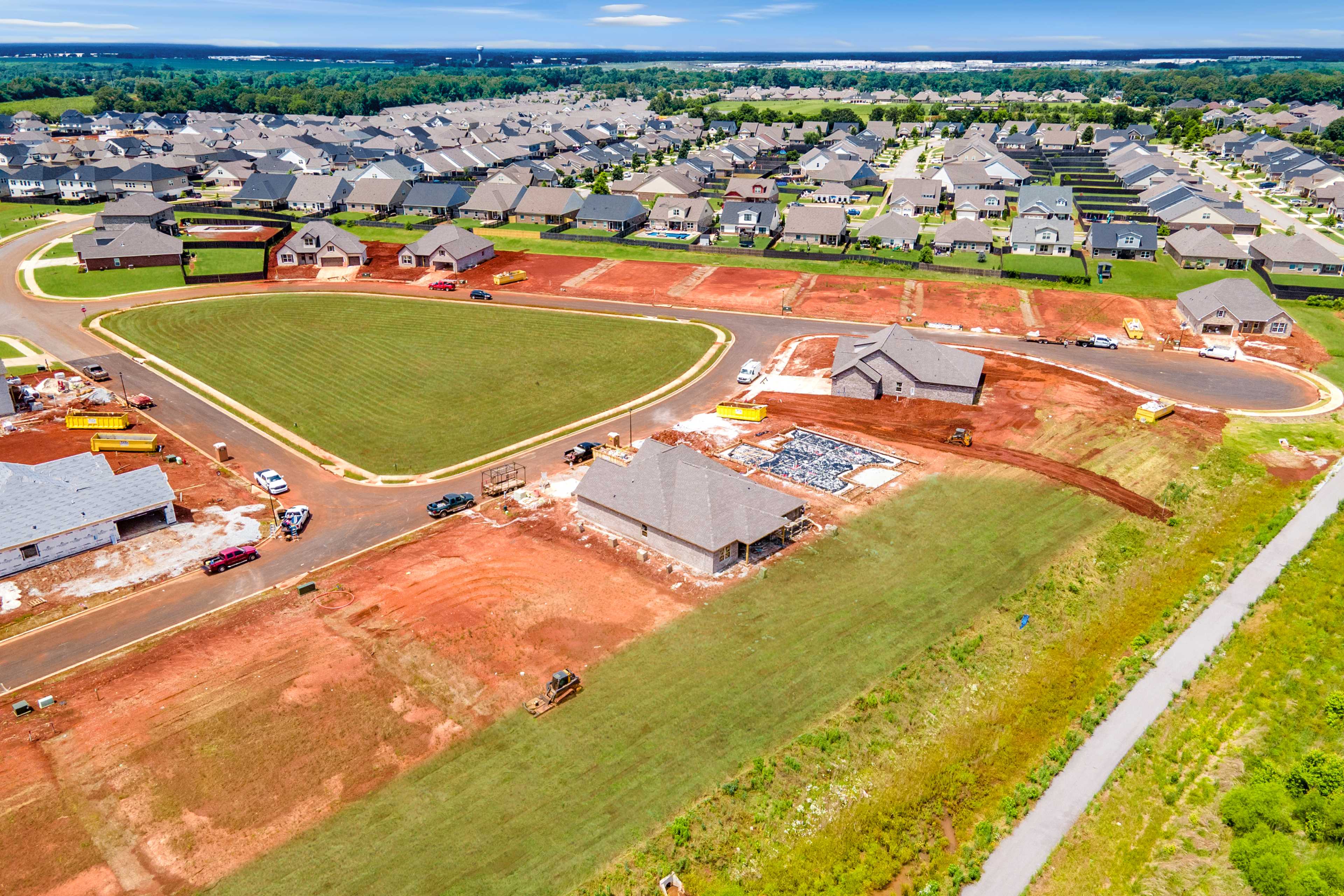 Aerial view of Barnett's Crossing in Madison Alabama featuring new construction homes, green fields, and developing lots by Davidson Homes