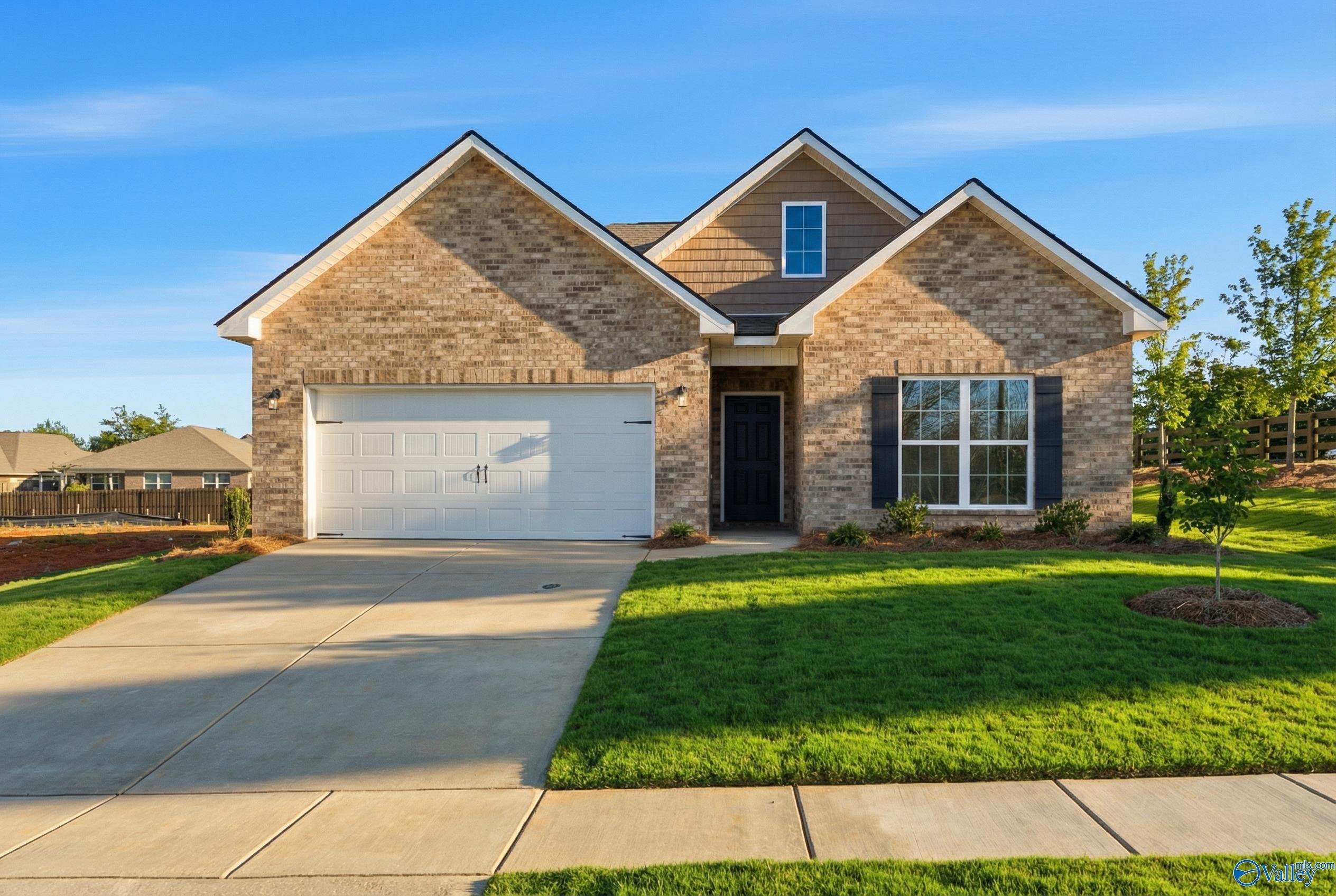 Modern brick 1-story home with 2-car garage, driveway, and lush green lawn in Flint Meadows, New Market, Alabama - Davidson Homes Franklin C