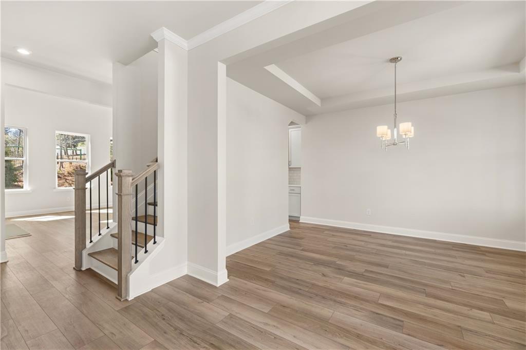 Spacious foyer with oak staircase, hardwood floors, and chandelier in Davidson Homes The Danbury C, Buford, GA
