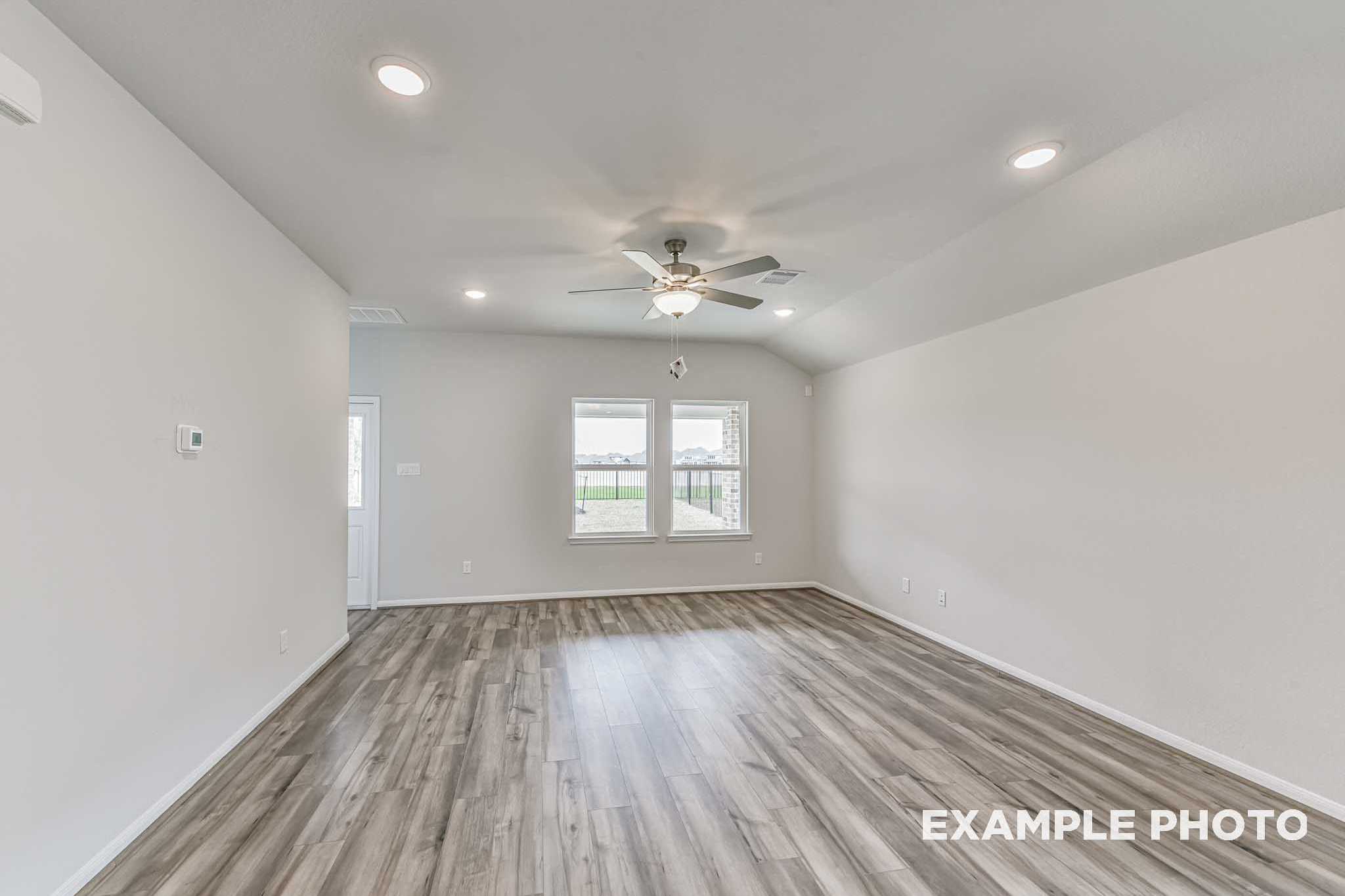 Spacious living room in The Laguna A with ceiling fan, recessed lights, large windows, and hardwood floors