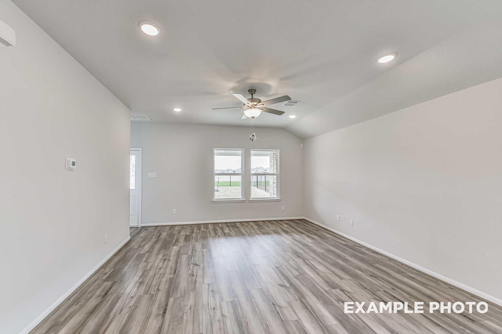 Spacious living room in The Laguna A with ceiling fan, recessed lights, large windows, and hardwood floors
