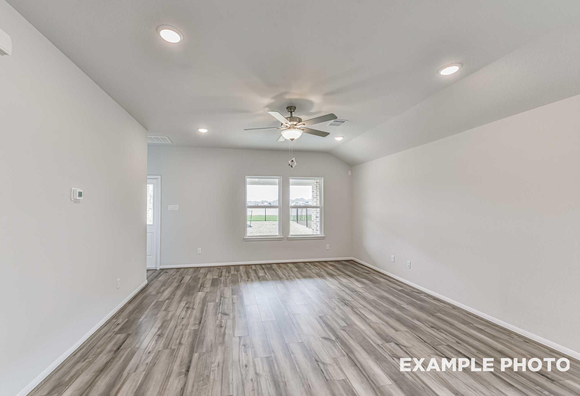 Spacious living room in The Laguna A with ceiling fan, recessed lights, large windows, and hardwood floors