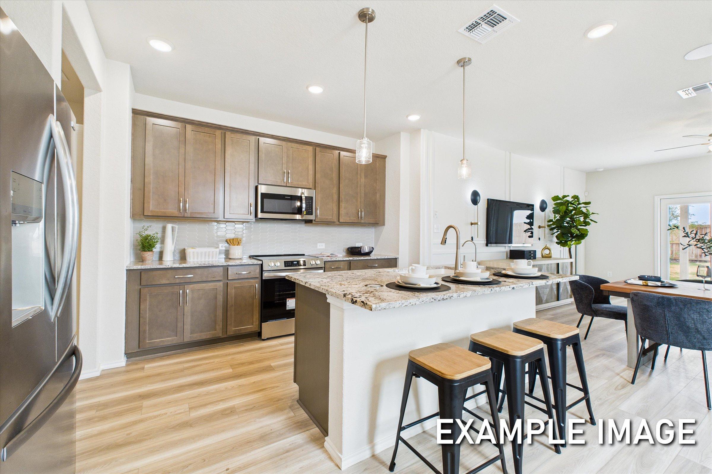 Spacious kitchen in The Brazos D showcasing granite island, stainless steel appliances, white cabinets, and open dining area
