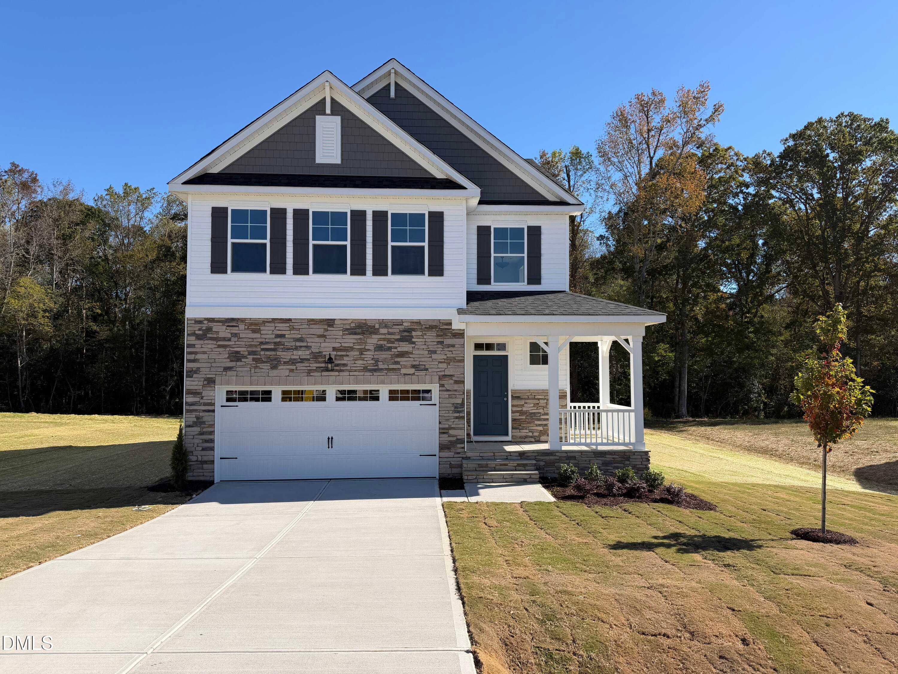 Two-story Davidson Homes The Gavin C exterior with stone garage, covered porch, and landscaped yard in Wellers Knoll, Lillington, NC