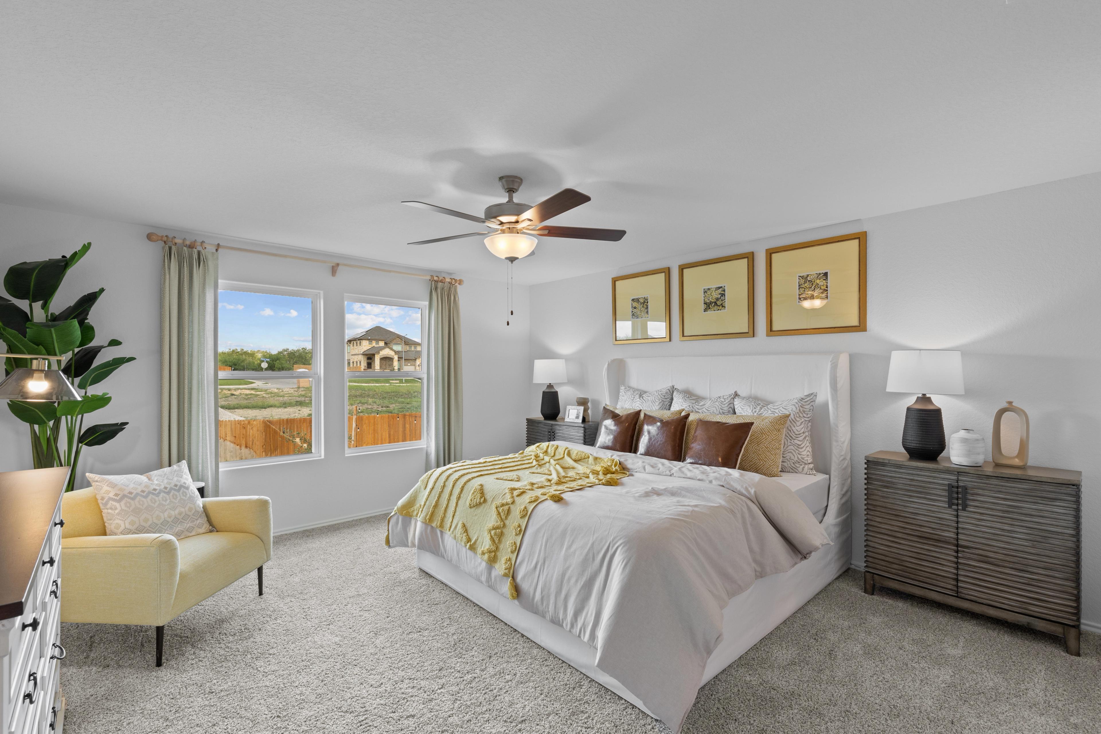 Spacious bedroom at Horizon Pointe in Converse Texas with king bed yellow accents ceiling fan and large windows