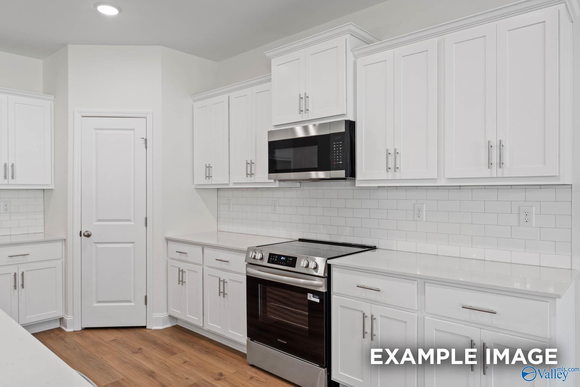 Modern kitchen featuring white shaker cabinets, stainless steel appliances, subway tile backsplash in Davidson Homes The Rockford C, Madison, AL