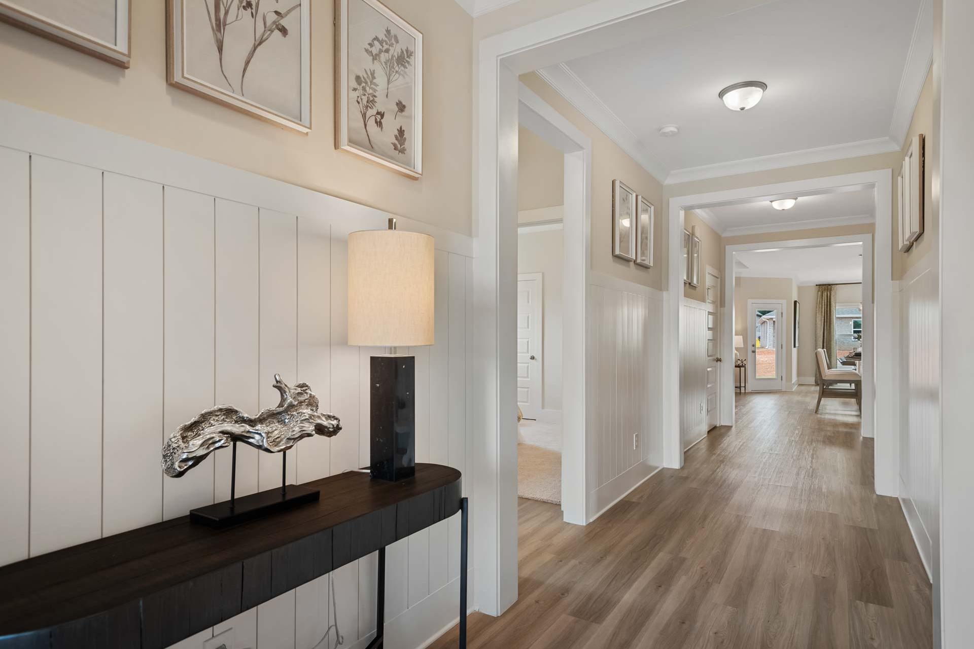 Spacious entry hallway at Flint Meadows in New Market Alabama with shiplap walls hardwood floors and console table