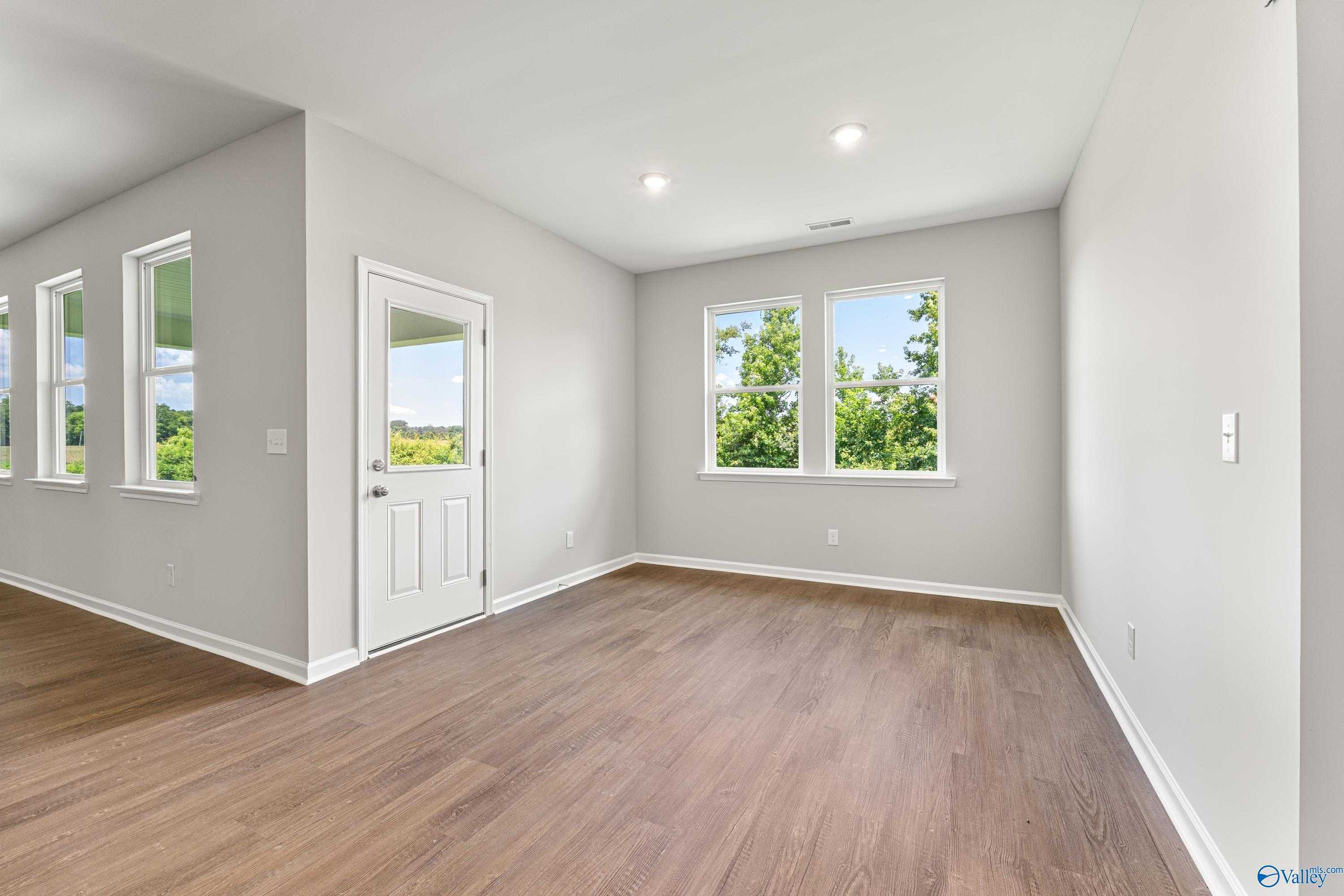 Bright home office with hardwood floors, gray walls, large windows, and French door in Davidson Homes The Sanctuary, Huntsville