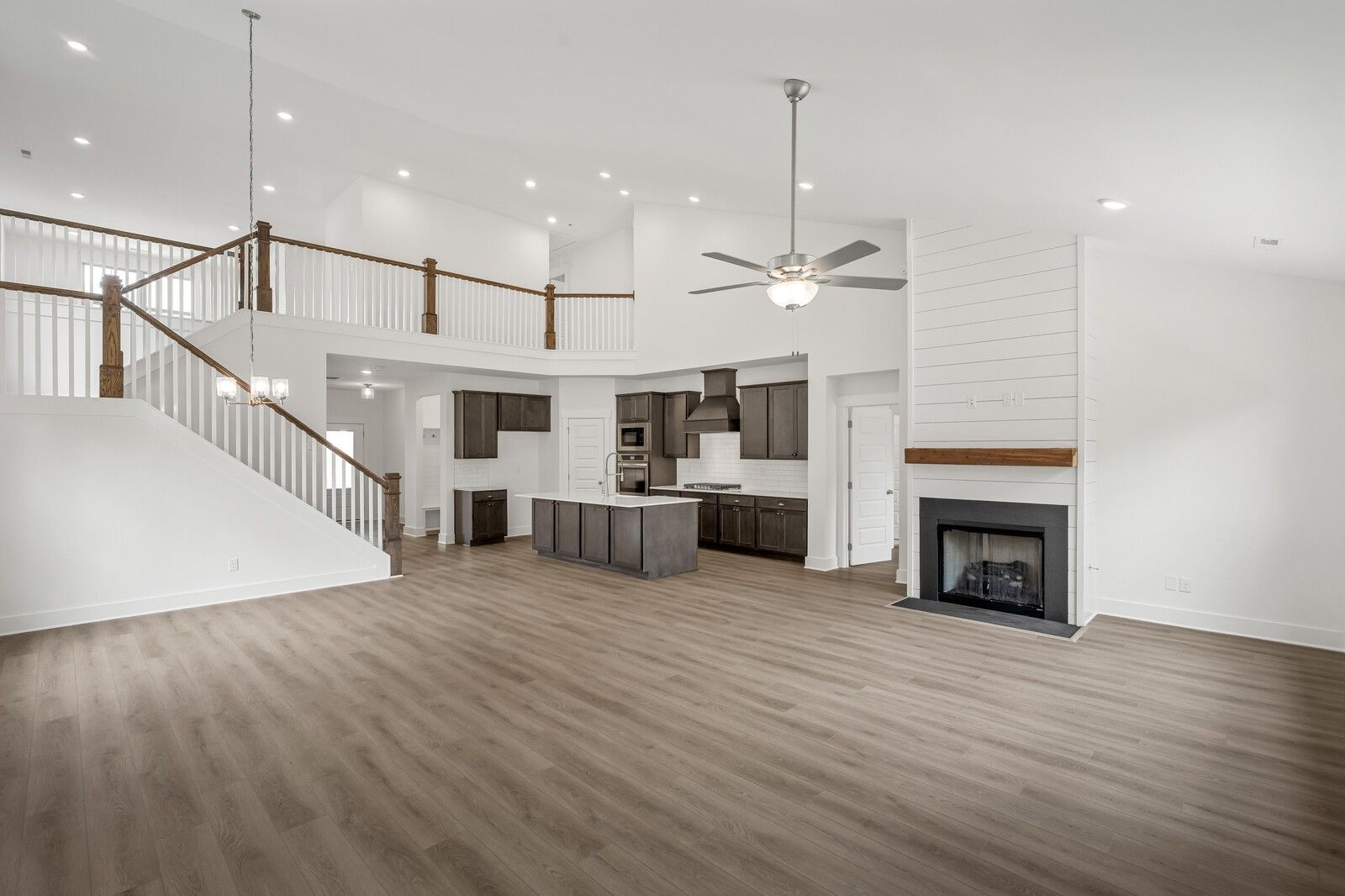Open-concept living room with fireplace and modern kitchen in The Ridgeport C floor plan at Woods Crossing, Gallatin, TN.