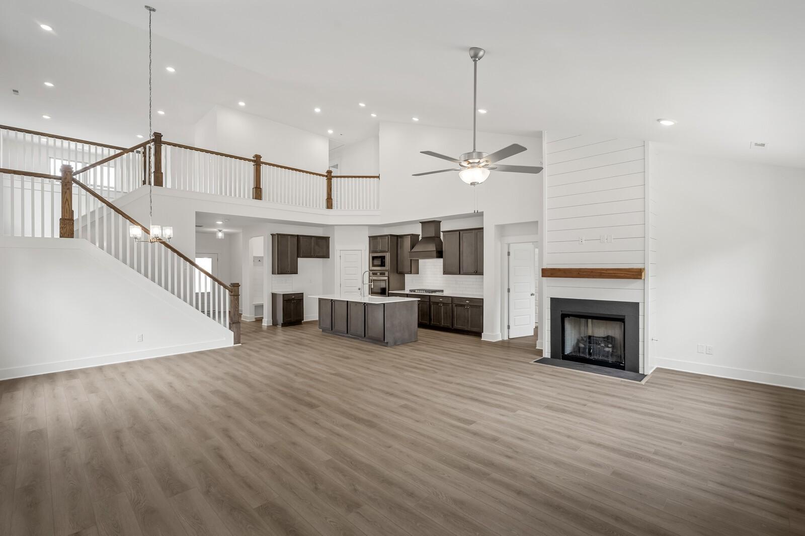Open-concept living room with fireplace and modern kitchen in The Ridgeport C floor plan at Woods Crossing, Gallatin, TN.