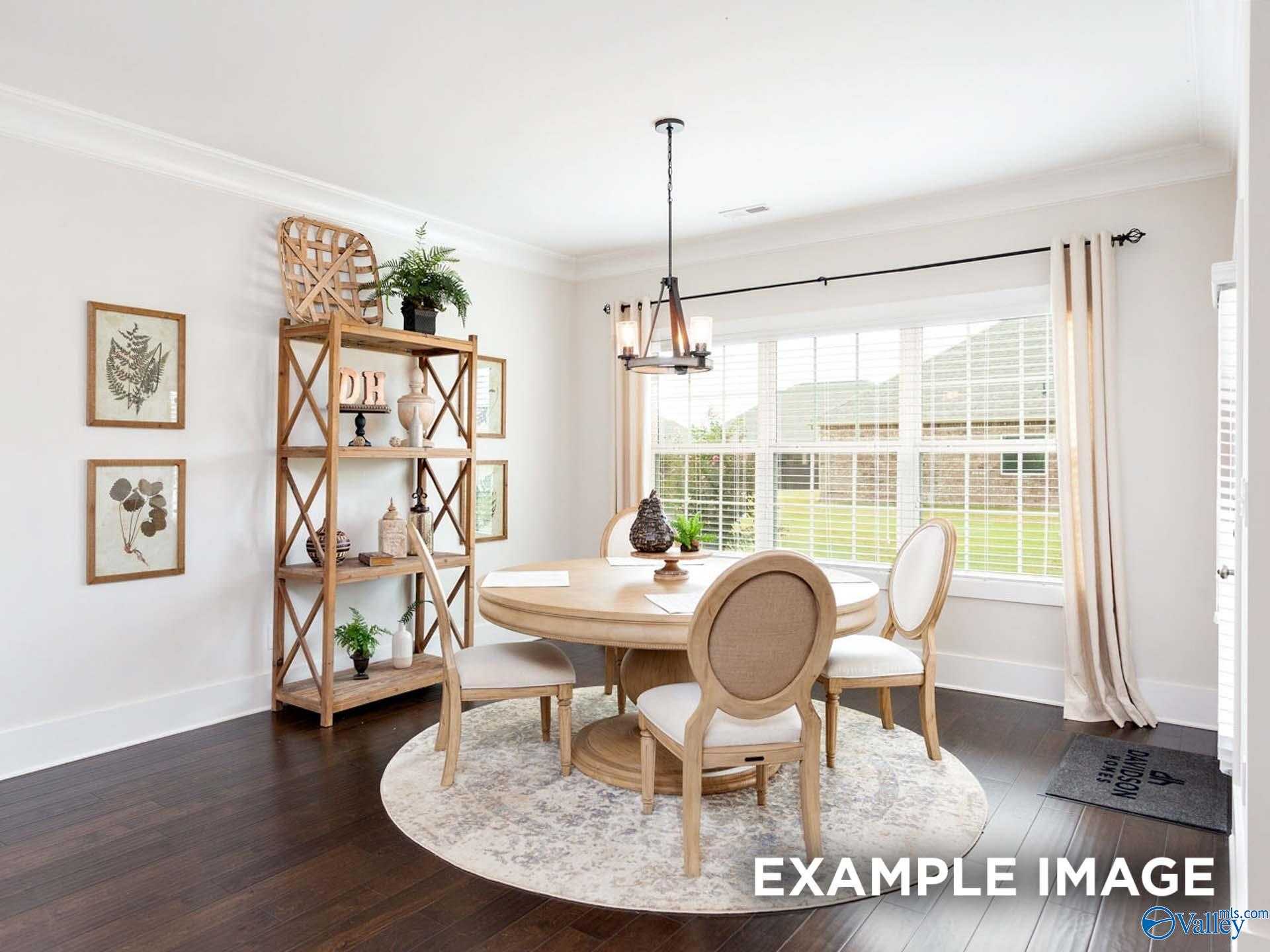 Elegant dining room with round table, tufted chairs, chandelier, bookshelves, and yard views in Davidson Homes Finleigh, Briercreek, Alabama