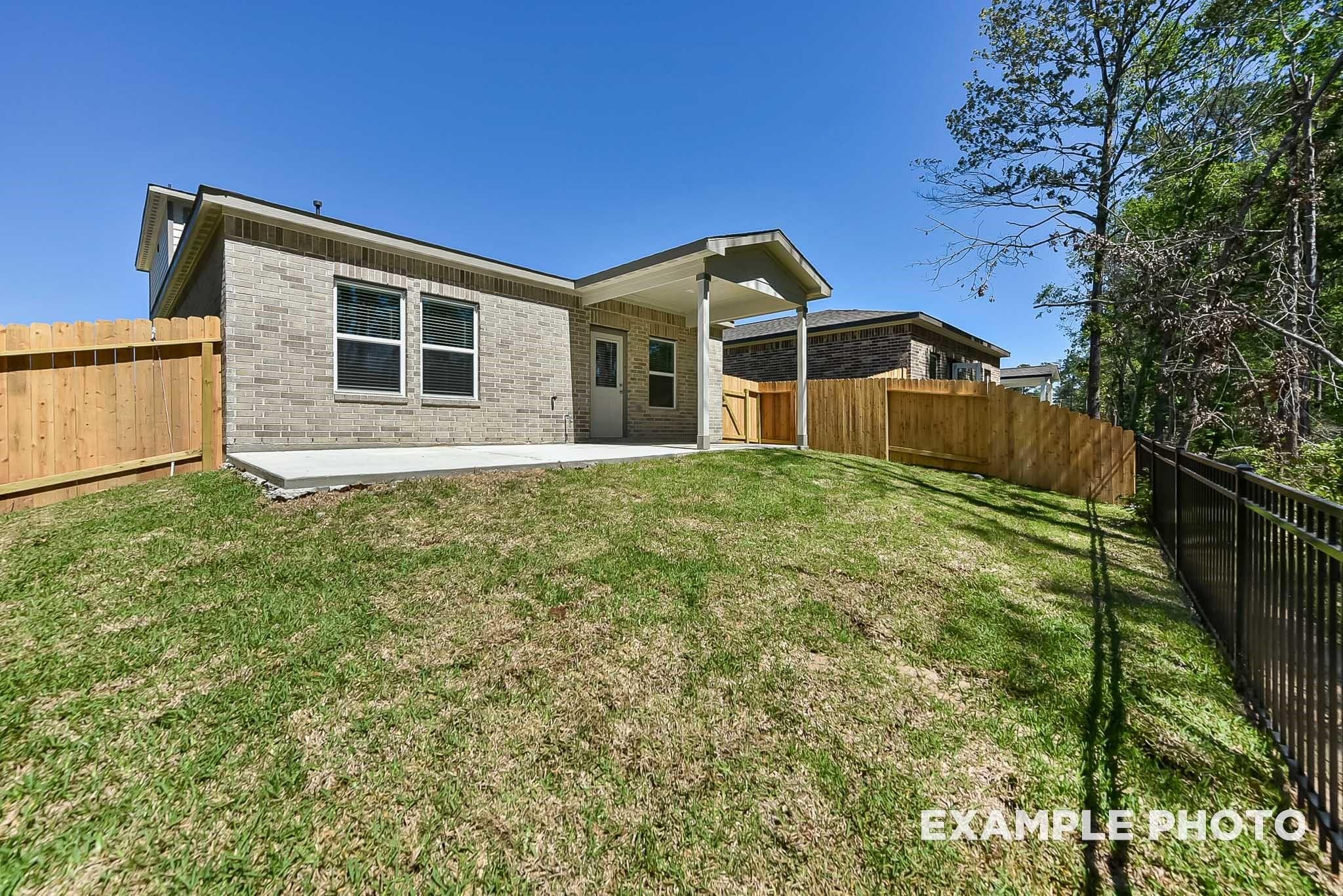 Covered patio and private backyard of The Blanco E floor plan in Caney Creek Place, Conroe, Texas.
