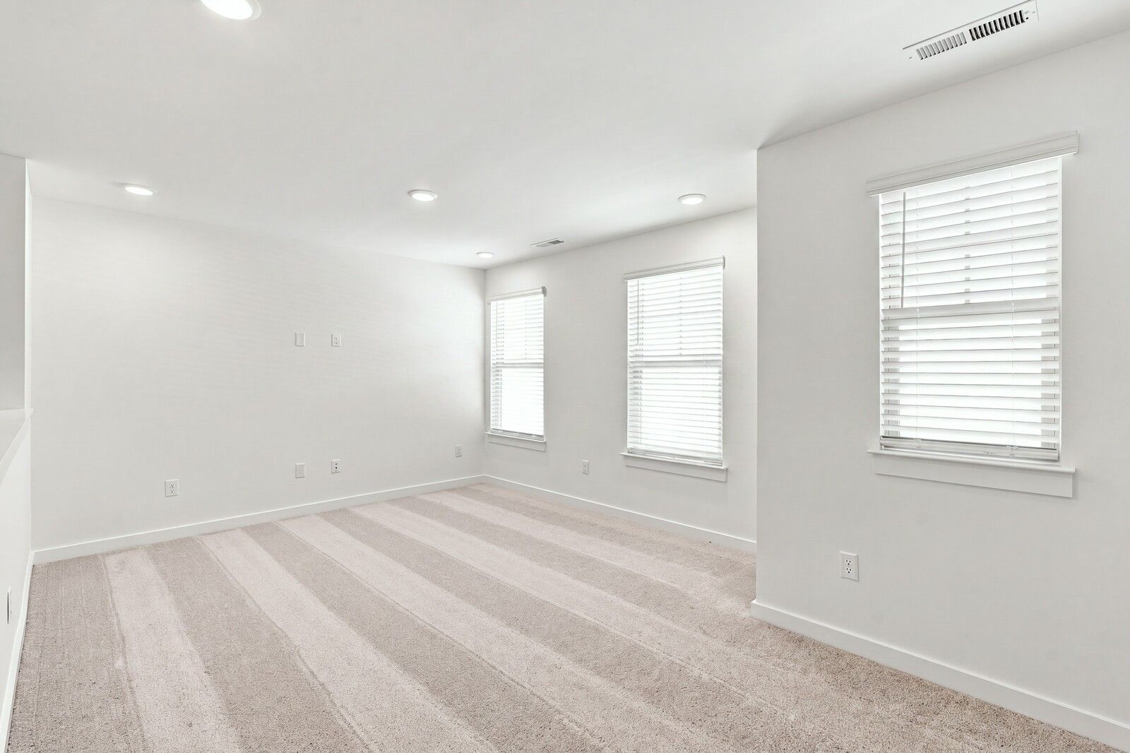 Bright spacious bedroom with carpet, white walls, and windows with blinds in Davidson Homes The Willow C, Gallatin, TN