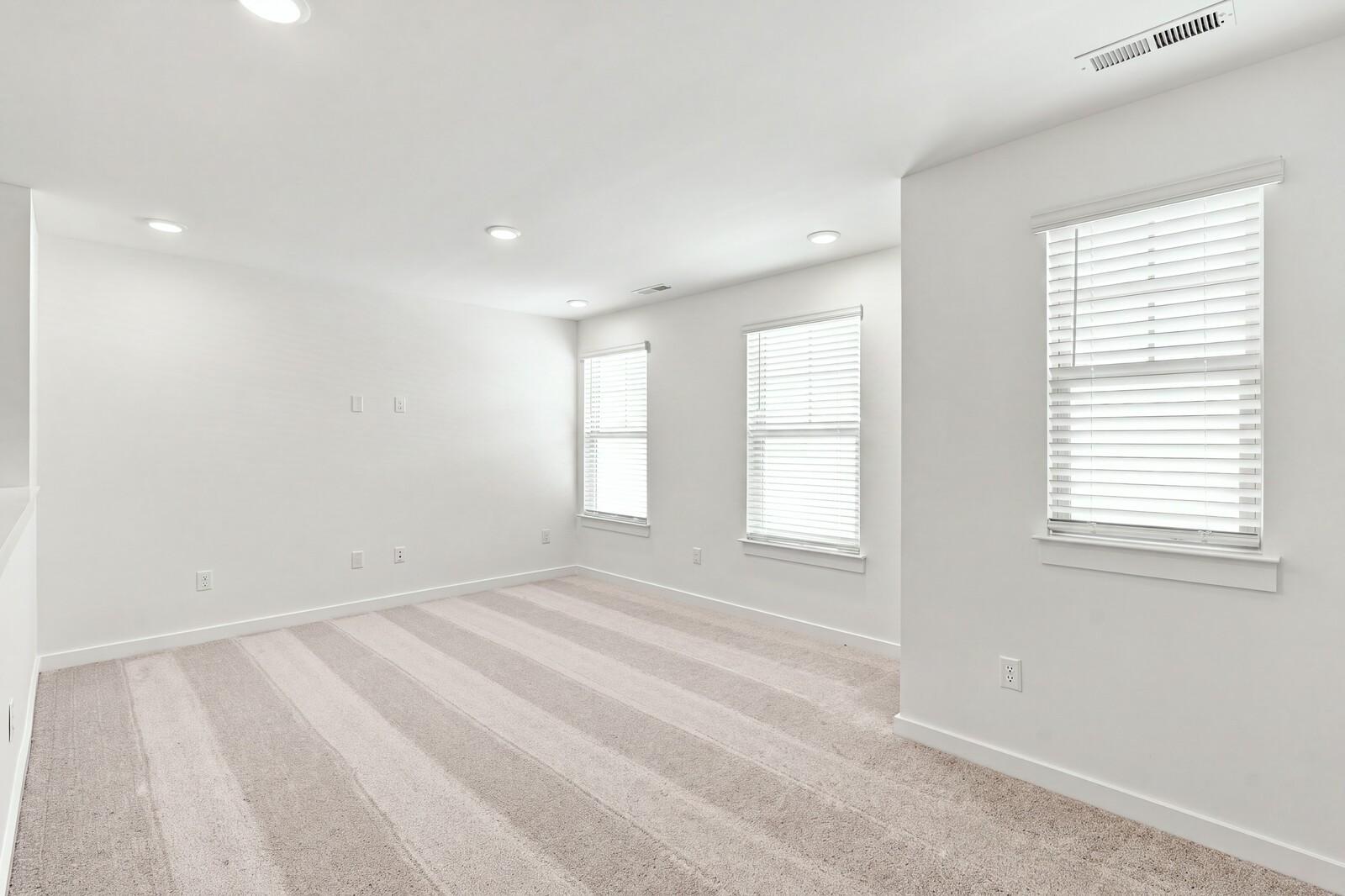 Bright spacious bedroom with carpet, white walls, and windows with blinds in Davidson Homes The Willow C, Gallatin, TN