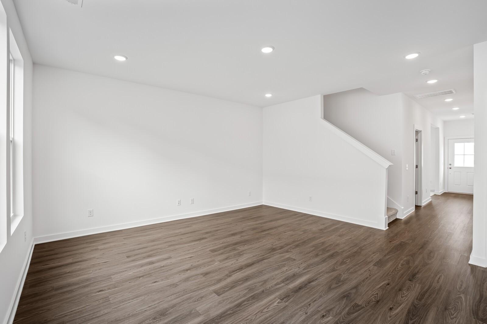 Bright entryway with hardwood floors, white walls, and staircase in The Logan C 3-bedroom home, Davidson Homes, Sage Farms, White House, TN