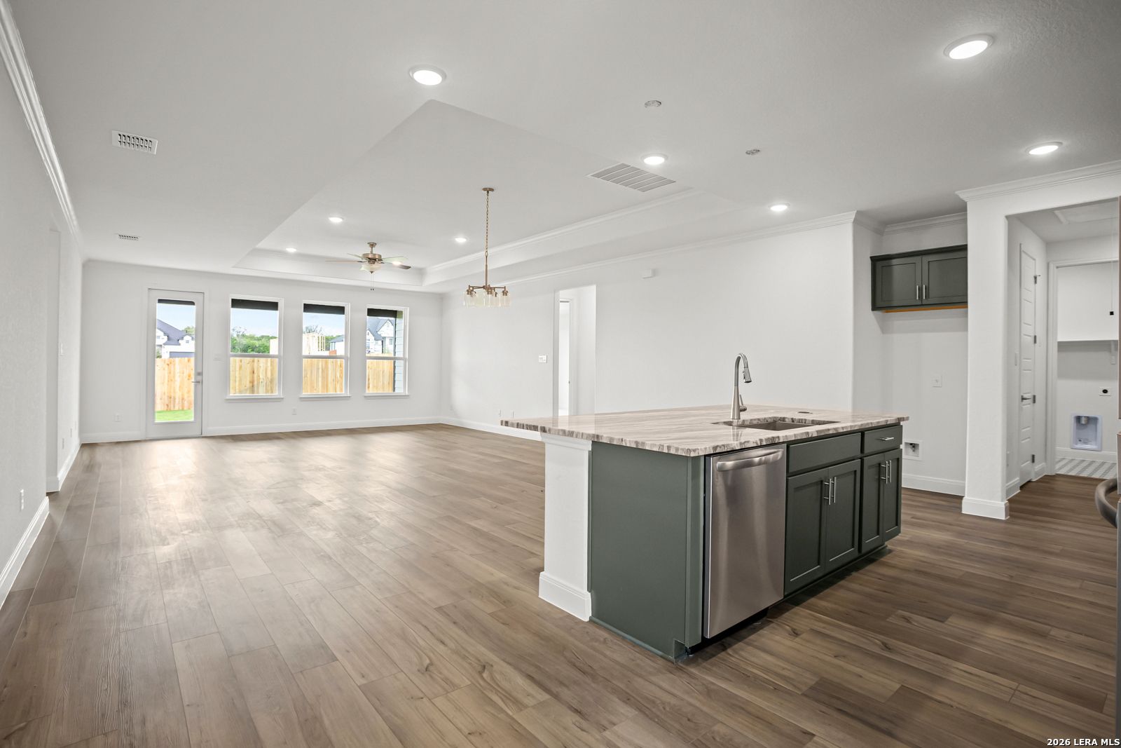 Open-concept kitchen and living area with tray ceiling in The Lanier G floor plan at The Reserve at Potranco Oaks.