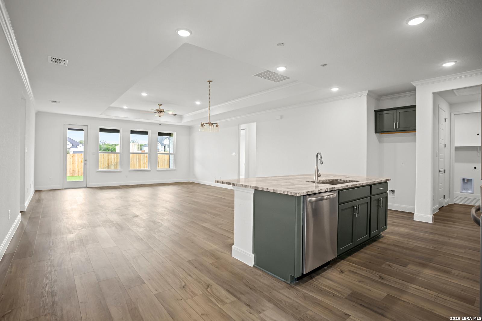 Open-concept kitchen and living area with tray ceiling in The Lanier G floor plan at The Reserve at Potranco Oaks.