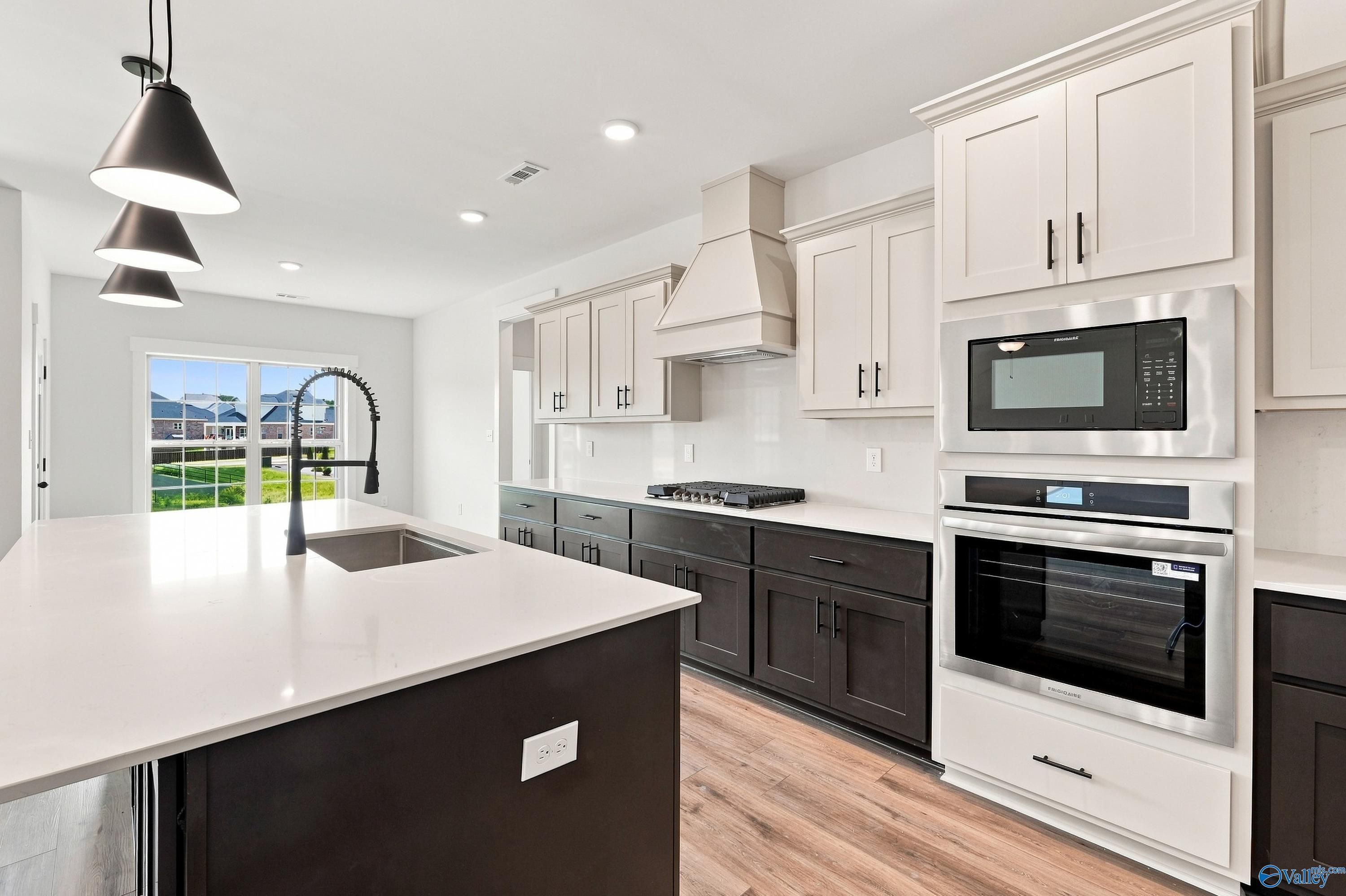 Modern kitchen with two-tone cabinets and large island in The Valencia floor plan at Riverton Preserve, Huntsville, Alabama.