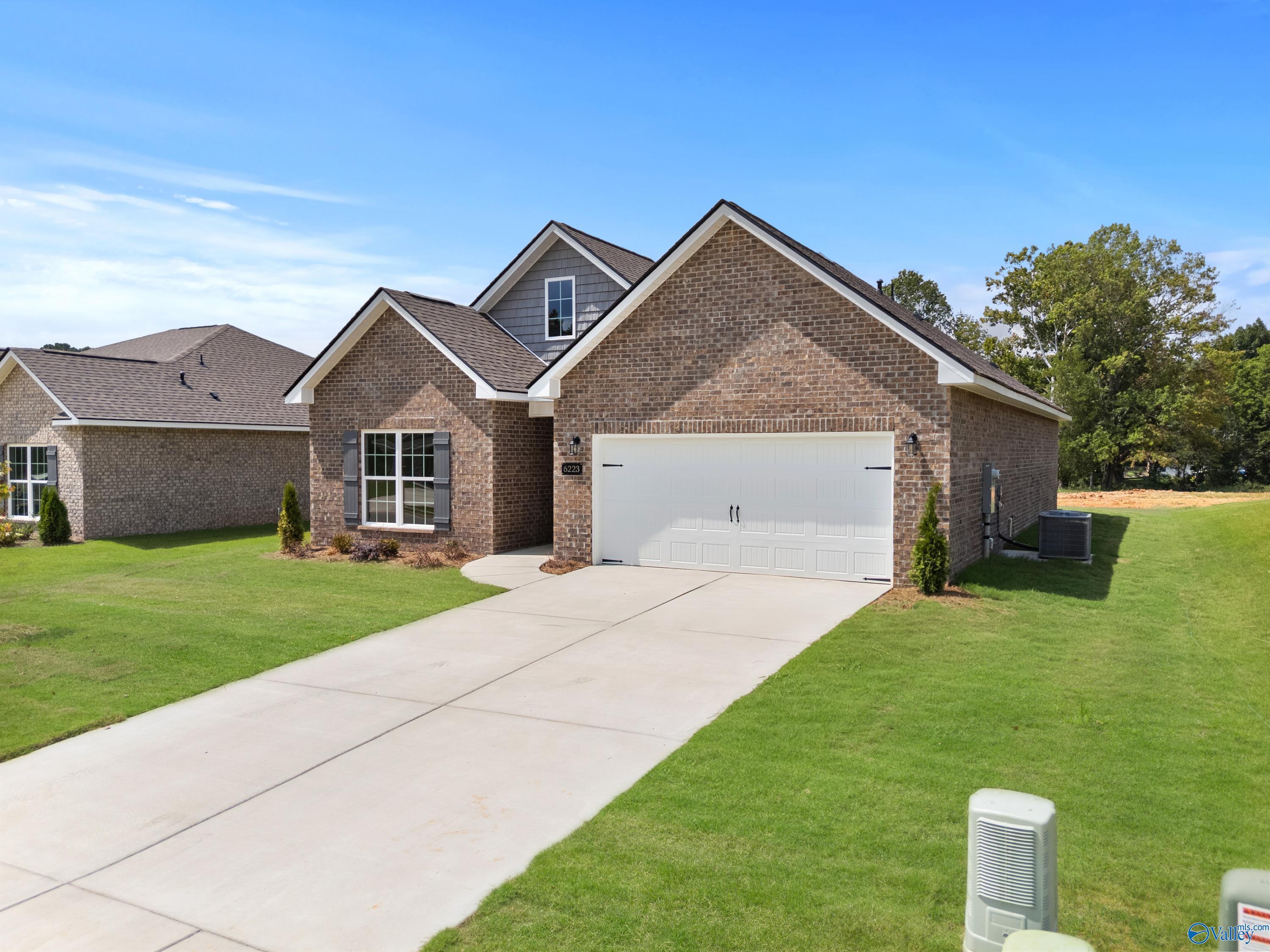 Brick single-story home with 2-car garage, driveway, and lush lawn in Spragins Cove, Huntsville, Alabama by Davidson Homes