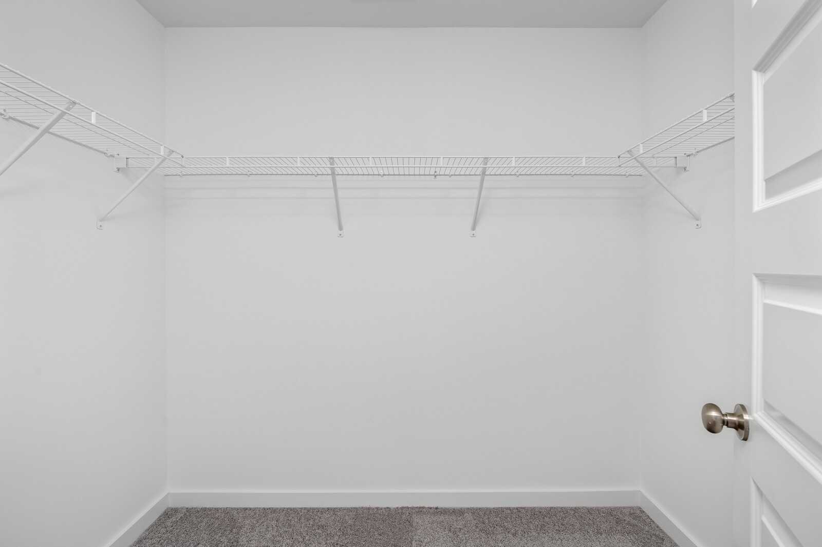 Spacious walk-in closet with wire shelving and open doors in Davidson Homes The Cumberland A, Gallatin, Tennessee