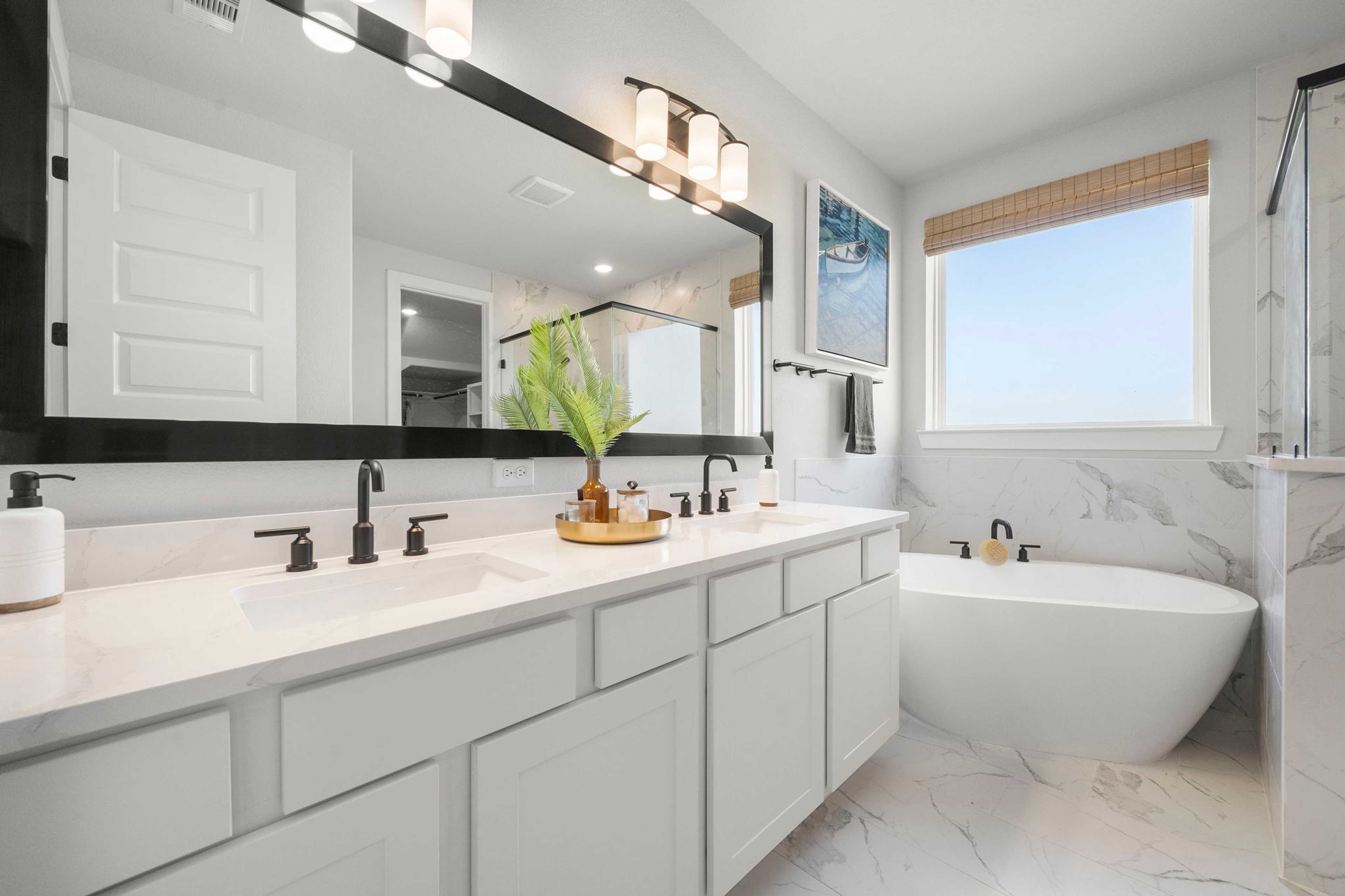 Luxury primary bathroom at Lago Mar in Texas City TX by Davidson Homes with double vanity, freestanding tub, and marble shower