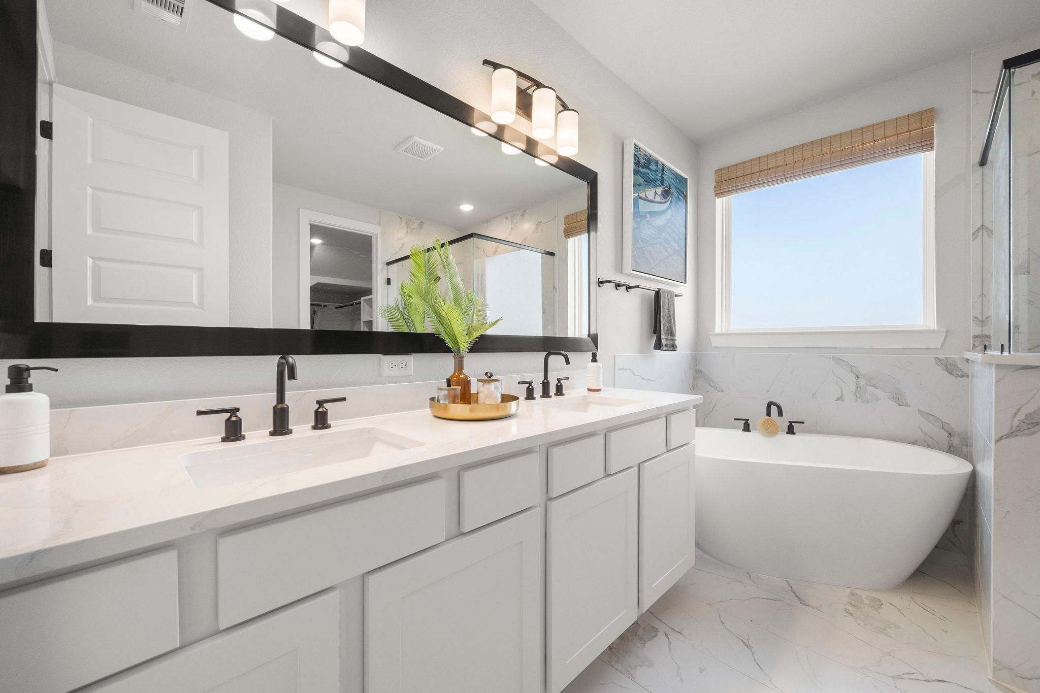 Luxury primary bathroom at Lago Mar in Texas City TX by Davidson Homes with double vanity, freestanding tub, and marble shower