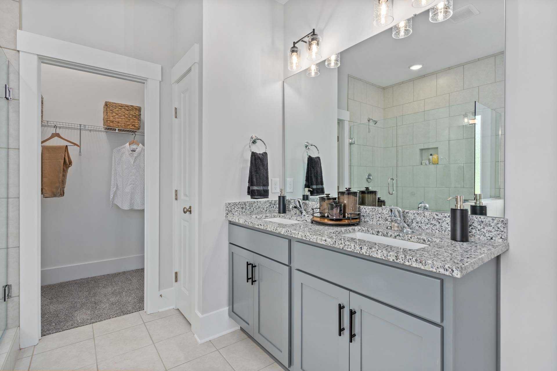 Spacious primary bathroom at Blue Spring in Huntsville AL with double gray vanity, quartz counters, and walk-in shower