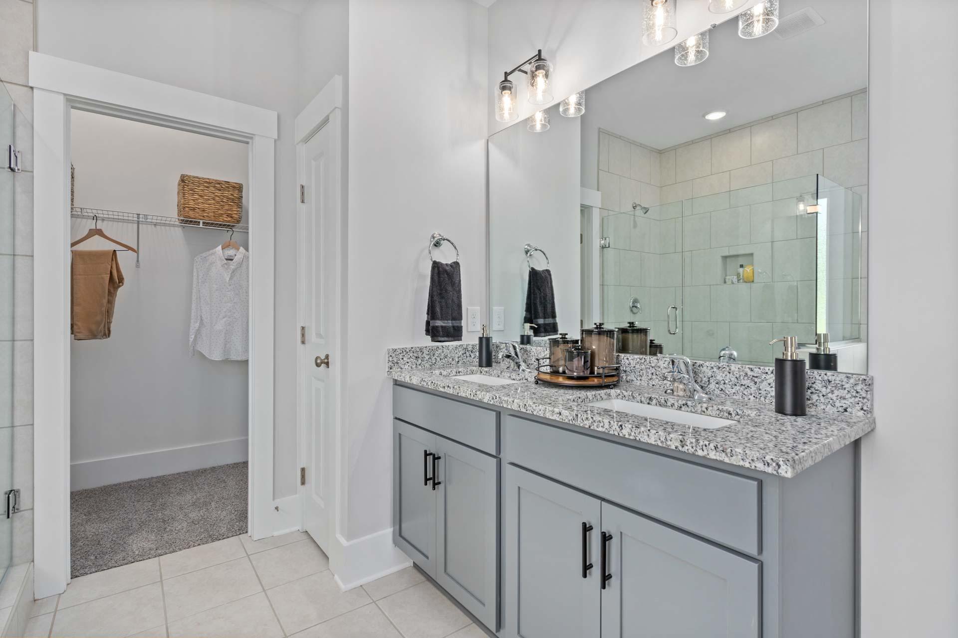 Spacious primary bathroom at Blue Spring in Huntsville AL with double gray vanity, quartz counters, and walk-in shower