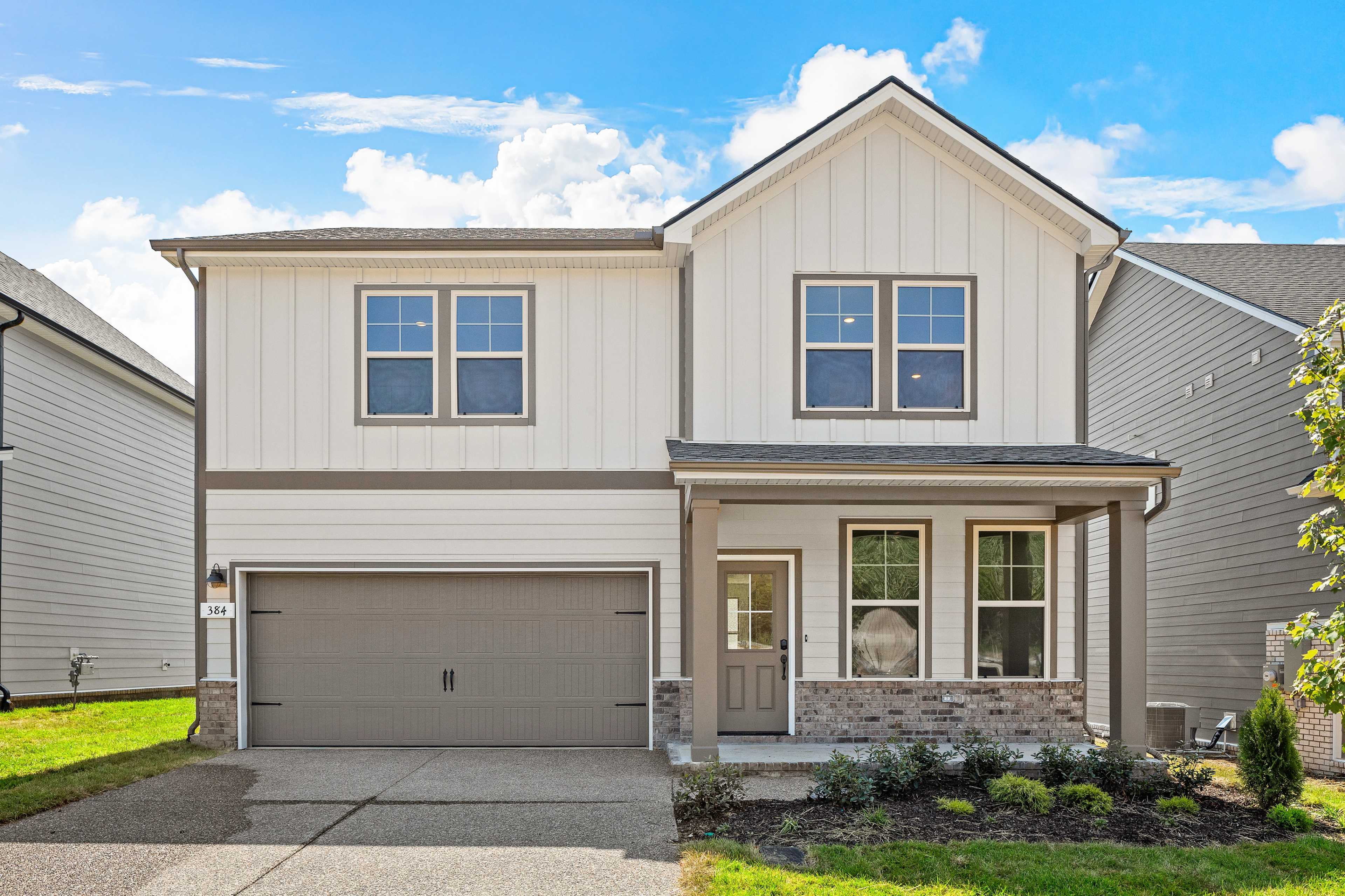 Modern farmhouse style home exterior at Woods Crossing in Gallatin, Tennessee with covered front porch and attached garage