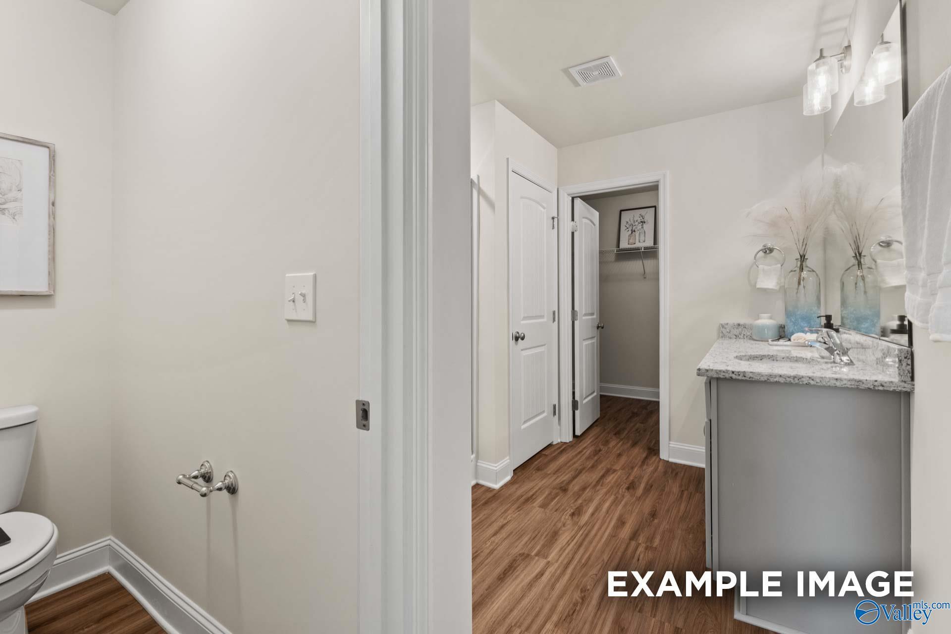 Luxurious bathroom with gray vanity, undermount sink, and hardwood floors in Davidson Homes The Franklin C, New Market, AL
