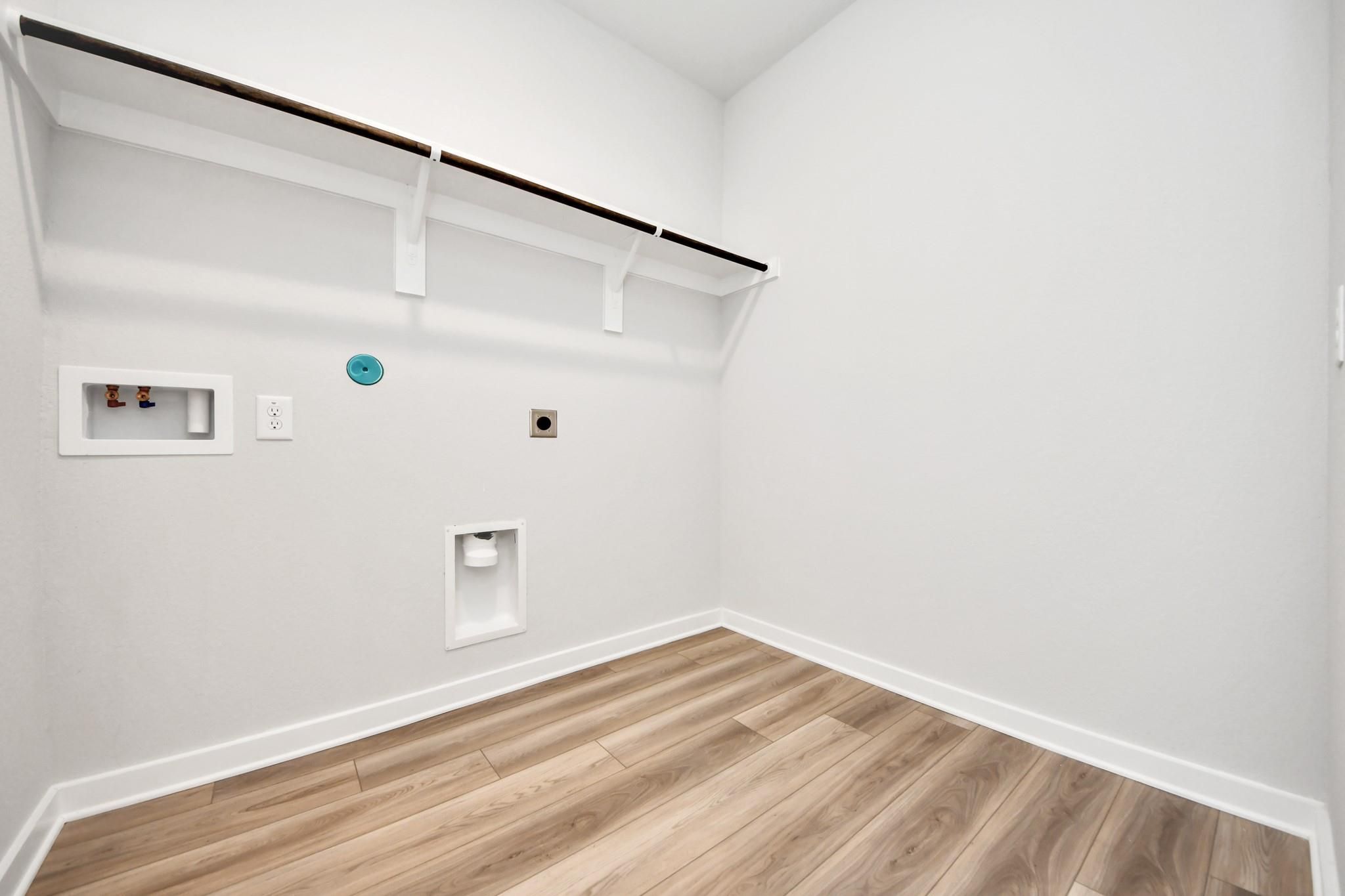 Dedicated laundry room with shelving in The Sorrento E floor plan by Davidson Homes in Sundance Cove, Crosby, Texas.