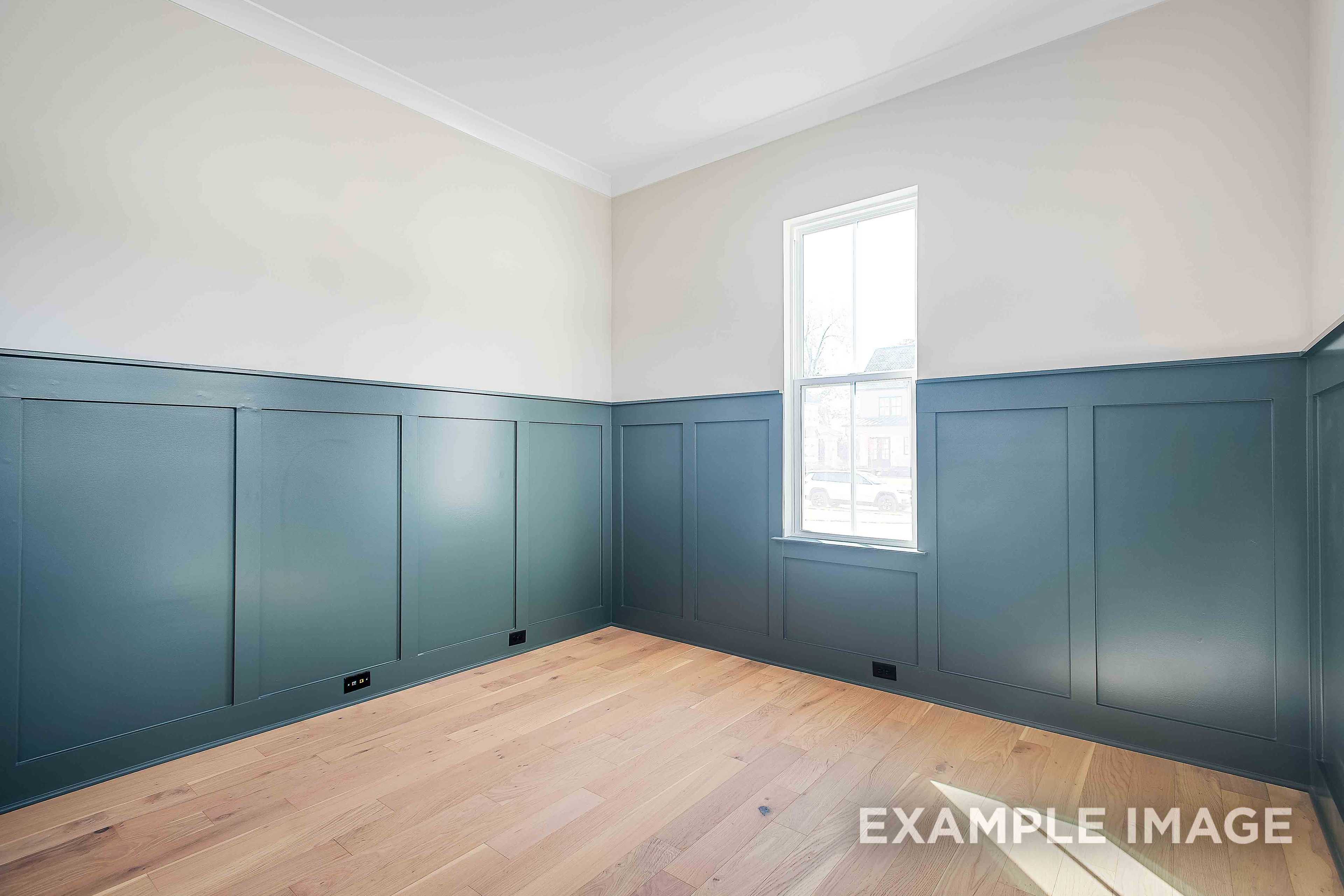 Spacious empty bedroom in The Alston A by Davidson Homes with navy wainscoting, hardwood floors, large window, Murfreesboro TN