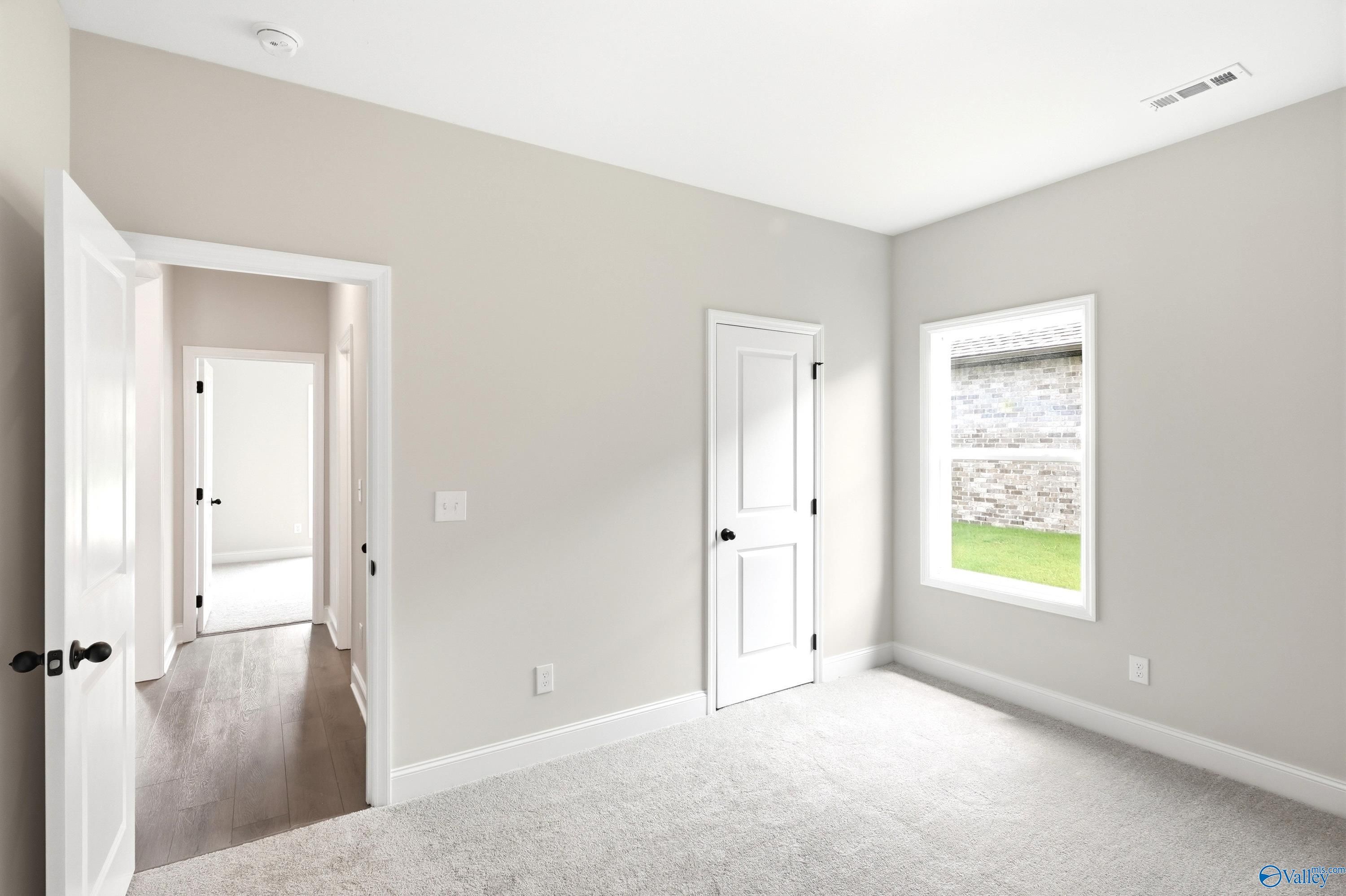 Bright bedroom with plush carpet in The Daphne floor plan by Davidson Homes at Lynn Meadows, Meridianville, Alabama.