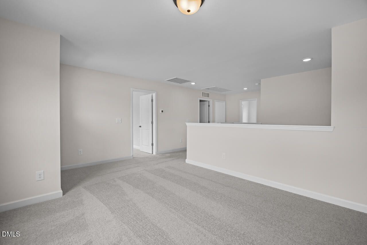 Spacious carpeted loft area in The Willow B floor plan by Davidson Homes in Woodland Crossing, Zebulon, North Carolina.