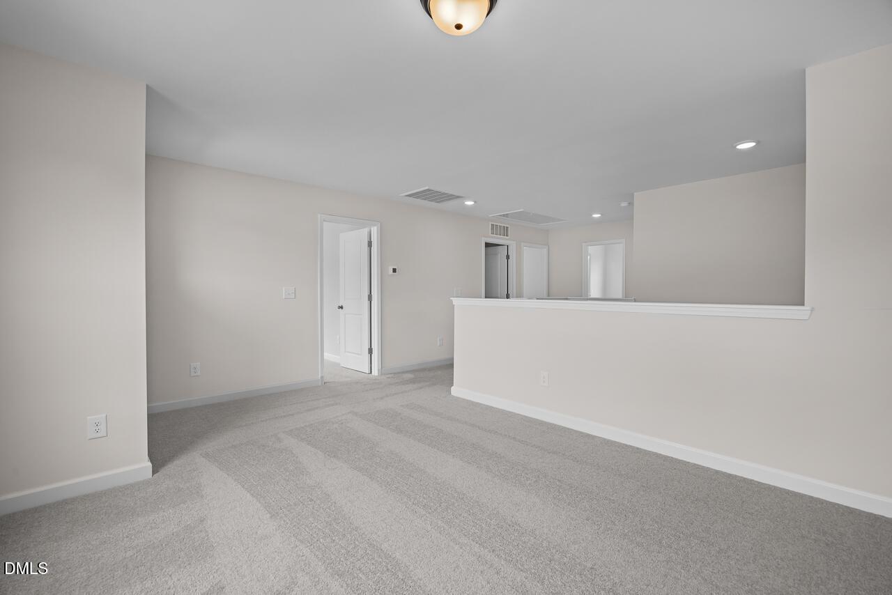 Spacious carpeted loft area in The Willow B floor plan by Davidson Homes in Woodland Crossing, Zebulon, North Carolina.