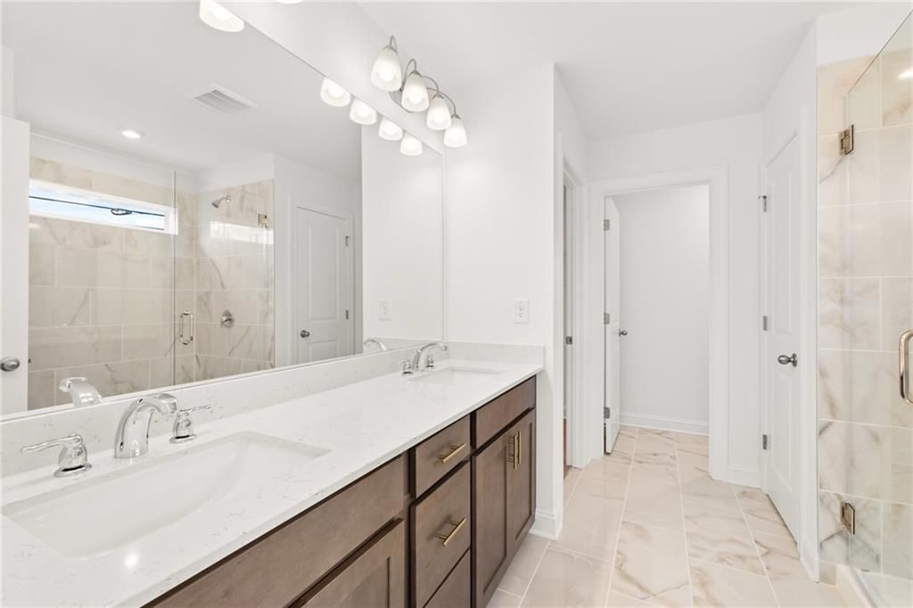 Spacious master bathroom with double vanity, frameless glass shower, and subway tile in Davidson Homes The Gavin E, Kennesaw, GA