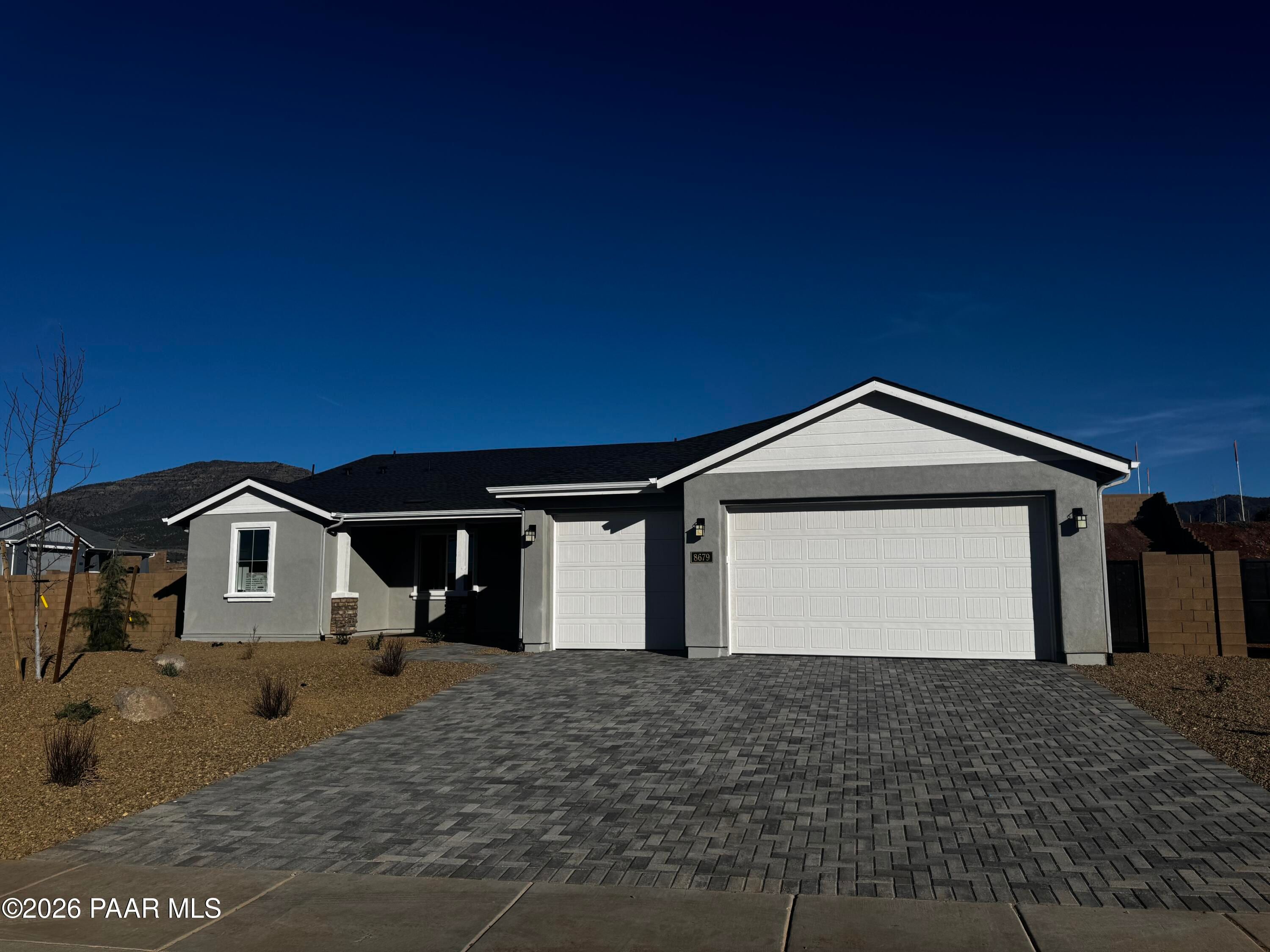 Modern single-story home with 3-car garage, paver driveway, and desert landscaping in Morningstar, Prescott Valley, Arizona