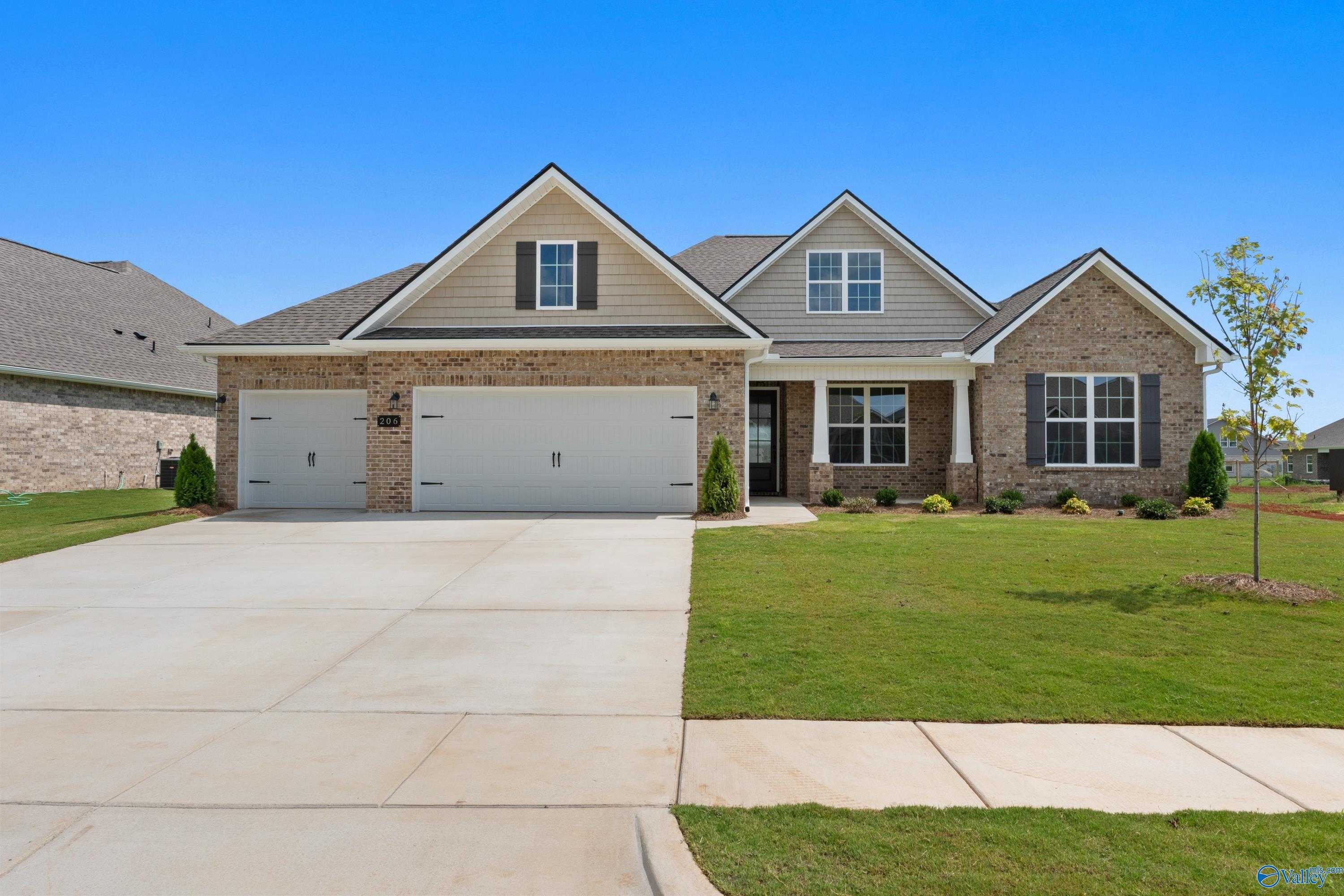 Brick 1-story home with 3-car garage, gabled roof, driveway, and landscaped yard in Kendall Farms, Toney, Alabama - Davidson Homes Rockford B