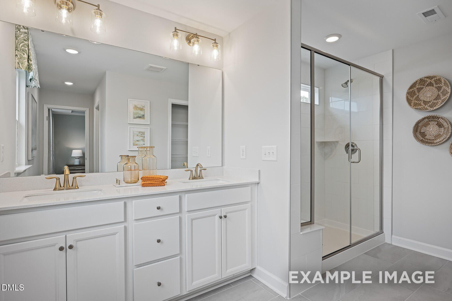 Modern bathroom with dual vanity and glass-enclosed shower in The Adalynn A floor plan by Davidson Homes in Zebulon, NC.