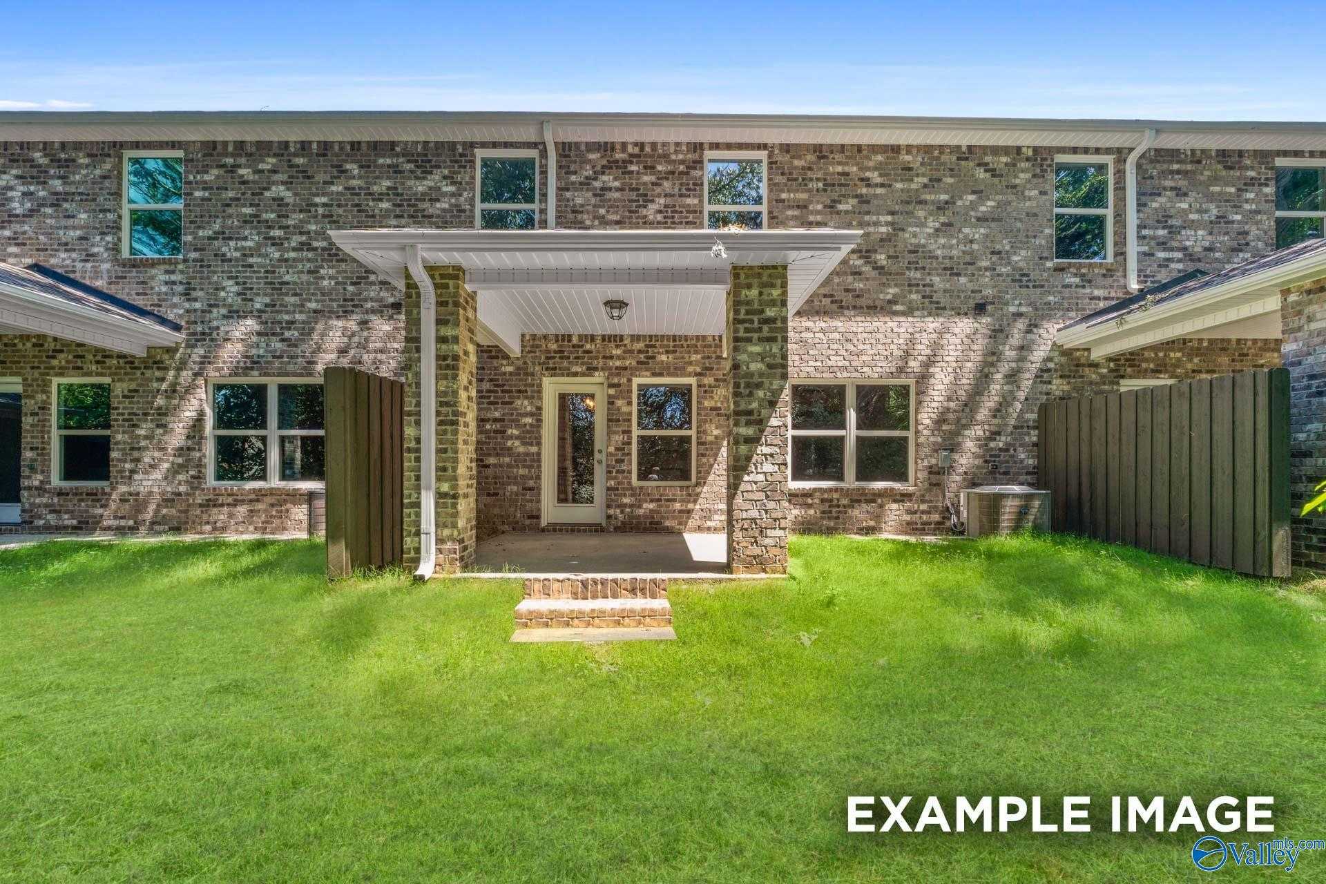 Two-story brick home with covered front porch, garage, and green lawn in Pavilion, Huntsville, Alabama - Davidson Homes Camden C