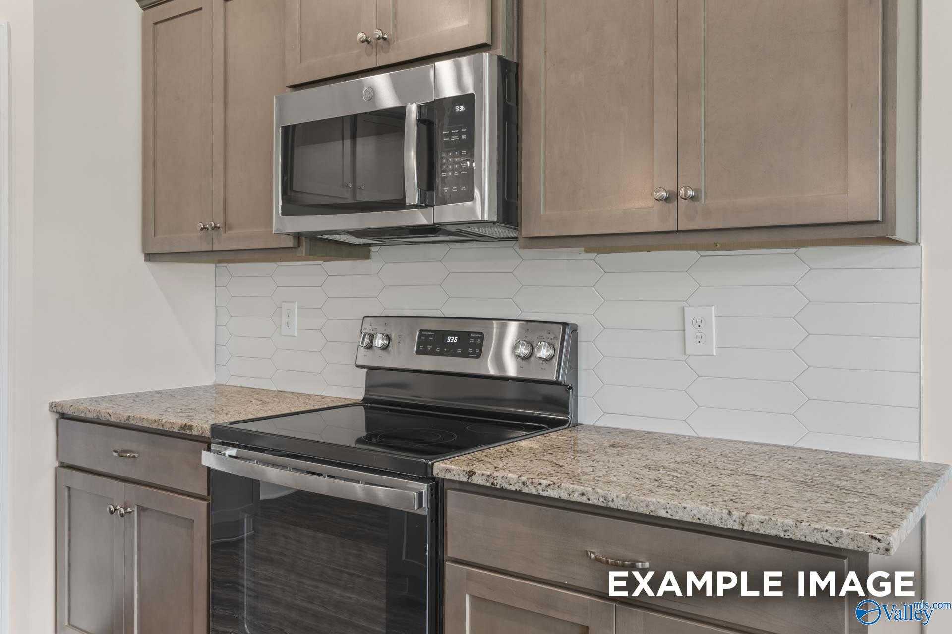 Modern kitchen featuring granite countertops, stainless steel appliances, subway tile backsplash in Davidson Homes The Asheville, Arab, Alabama