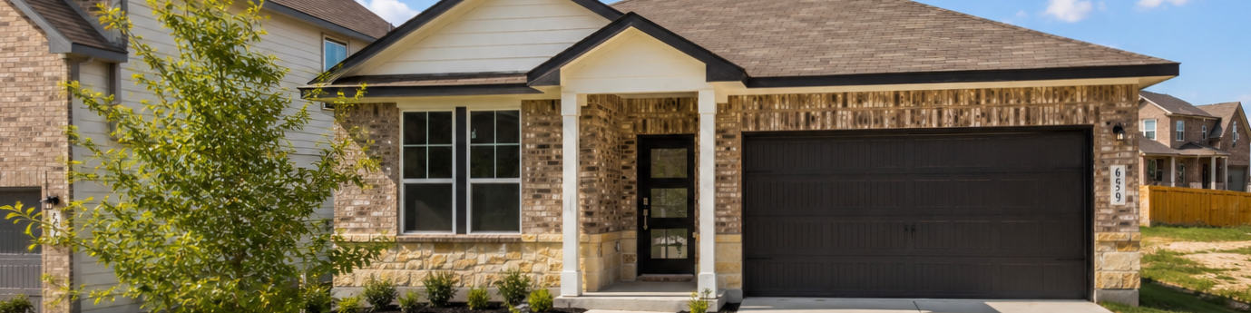 Single-story brick and stone home exterior by Davidson Homes at Saddle Creek Ranch in Cibolo, Texas with a two-car garage.
