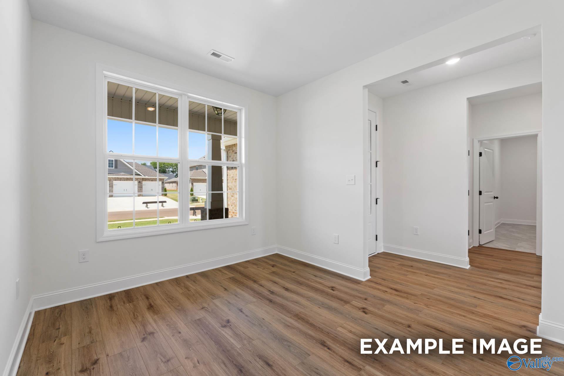 Bright bedroom with wood-look flooring in The Rockford B floor plan by Davidson Homes in Briercreek, Meridianville, AL.