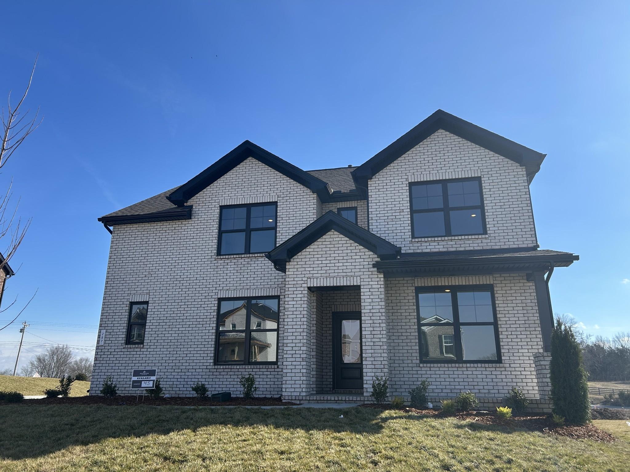 Modern 2-story brick home with black accents, large windows, and landscaped yard in Benders Cove, Mt. Juliet, TN